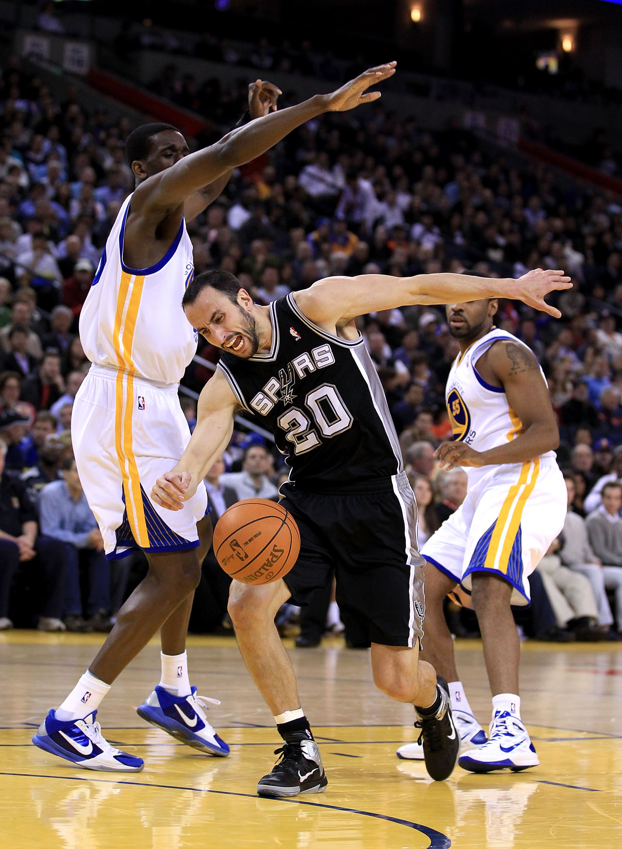 OAKLAND, CA - JANUARY 24:  Manu Ginobili #20 of the San Antonio Spurs drives on Ekpe Udoh #20 of the Golden State Warriors at Oracle Arena on January 24, 2011 in Oakland, California.  NOTE TO USER: User expressly acknowledges and agrees that, by downloadi