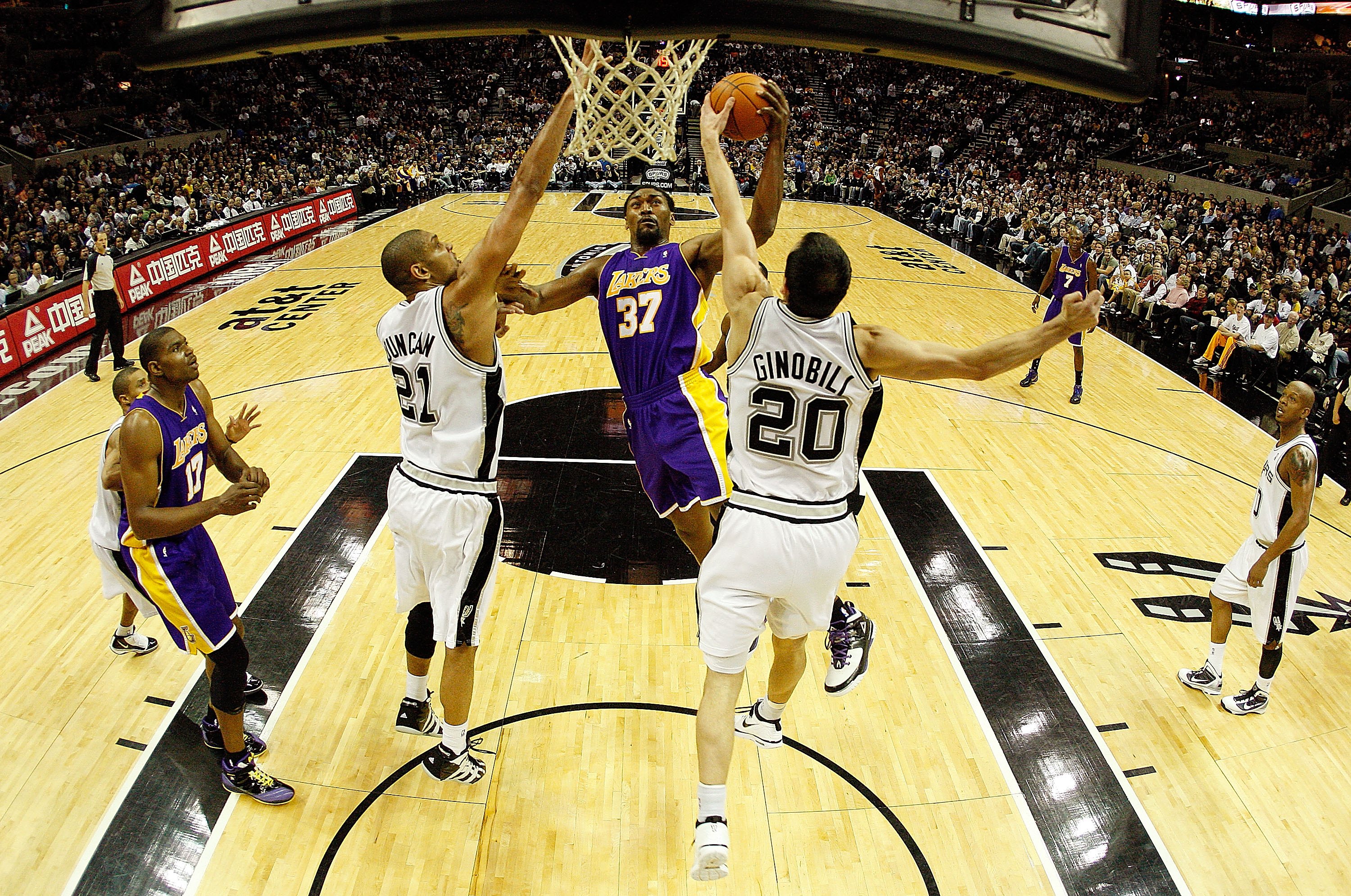 SAN ANTONIO - JANUARY 12:  Forward Ron Artest #37 of the Los Angeles Lakers takes a shot against Tim Duncan #21 and Manu Ginobili #20 of the San Antonio Spurs on January 12, 2010 at AT&T Center in San Antonio, Texas.  NOTE TO USER: User expressly acknowle