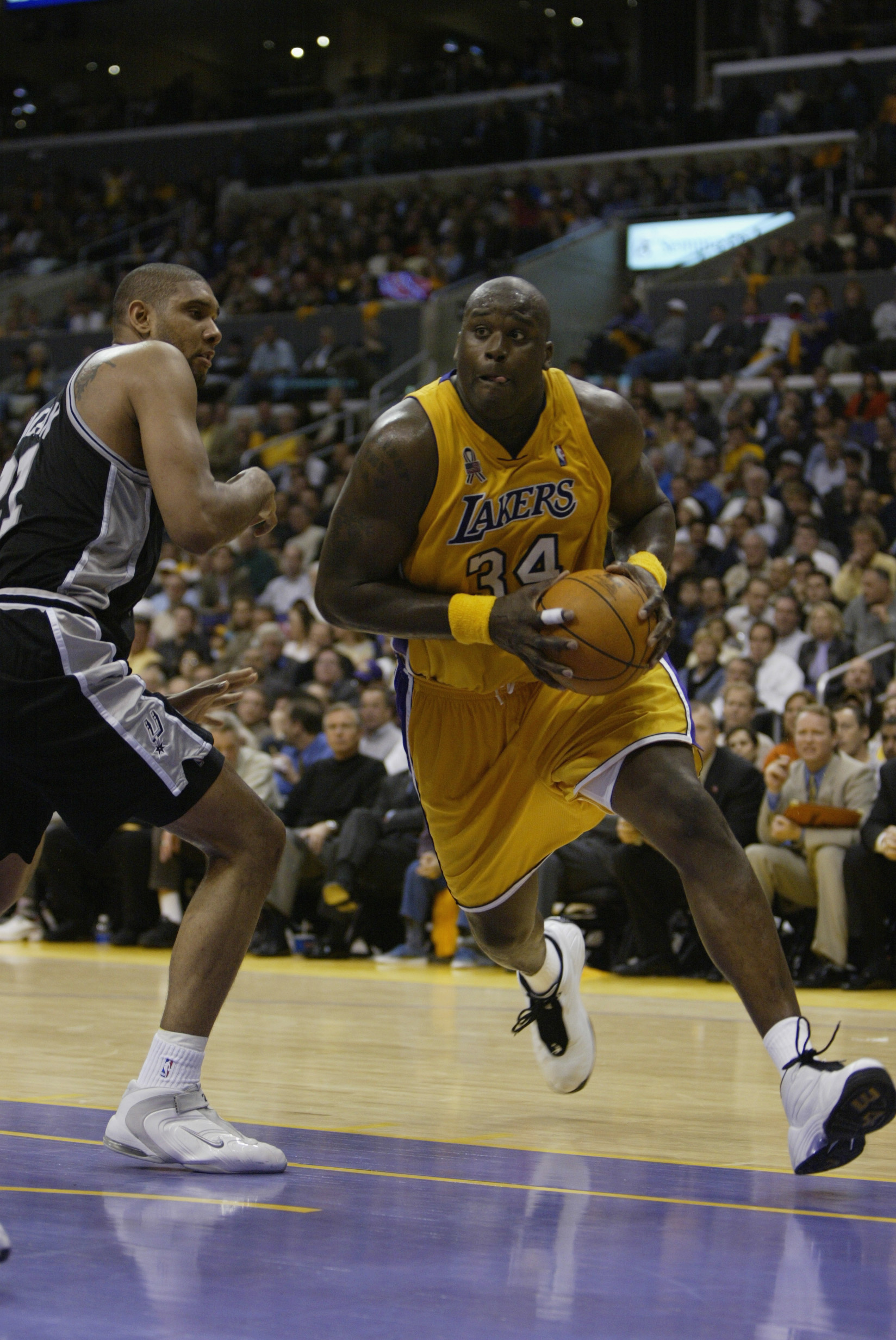 LOS ANGELES - MAY 7:  Shaquille O'Neal #34 of the Los Angeles Lakers drives to the basket past Tim Duncan #21 of the San Antonio Spurs during game two of the Western Conference Semifinals at the 2002 NBA Playoffs at Staples Center in Los Angeles, Californ
