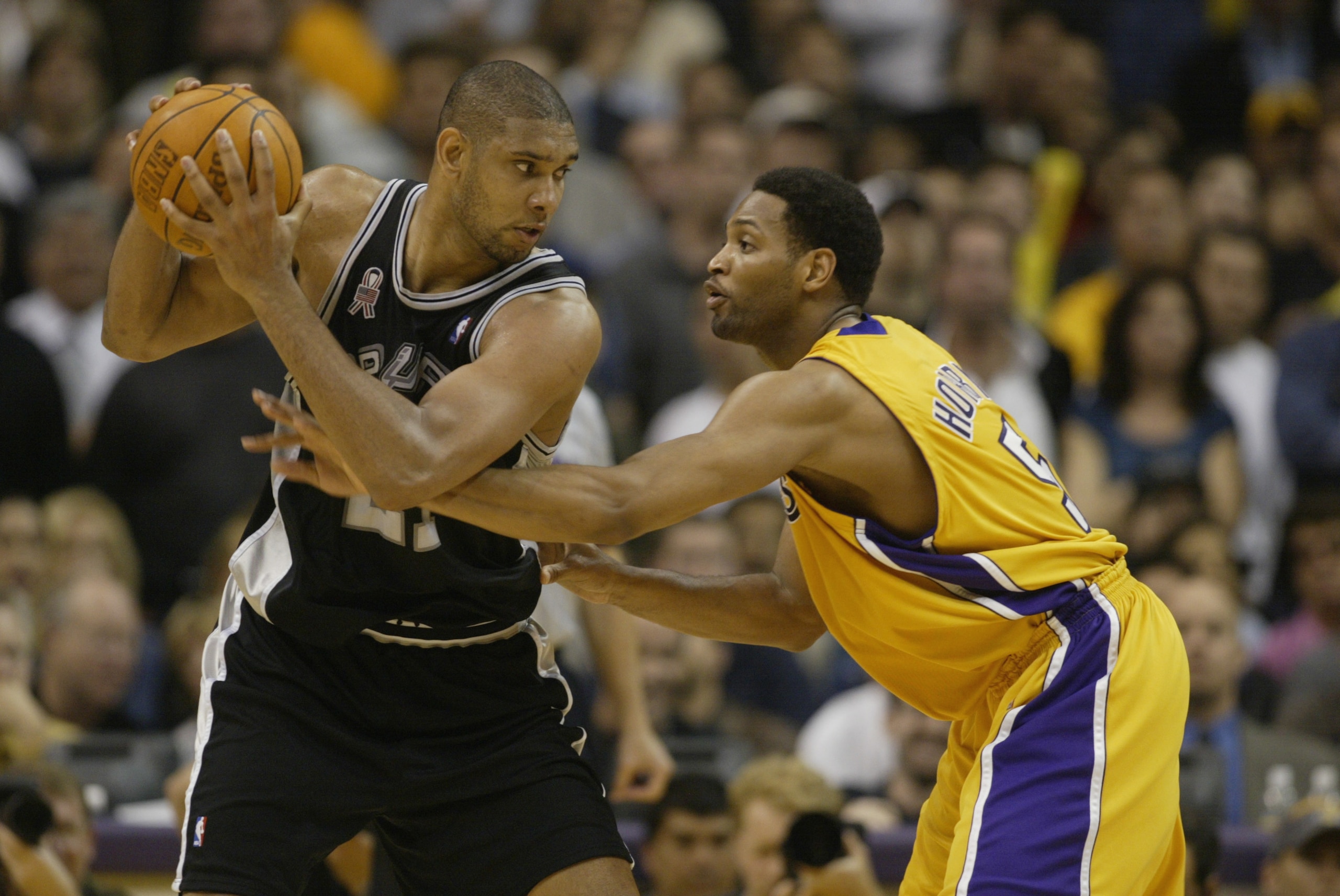 LOS ANGELES - MAY 7: Tim Duncan #21 of the San Antonio Spurs holds the ball away from Robert Horry #5 of the Los Angeles Lakers during game two of the Western Conference Semifinals during the 2002 NBA Playoffs at Staples Center in Los Angeles, California LOS ANGELES - MAY 7: Tim Duncan #21 of the San Antonio Spurs holds the ball away from Robert Horry #5 of the Los Angeles Lakers during game two of the Western Conference Semifinals during the 2002 NBA Playoffs at Staples Center in Los Angeles, California