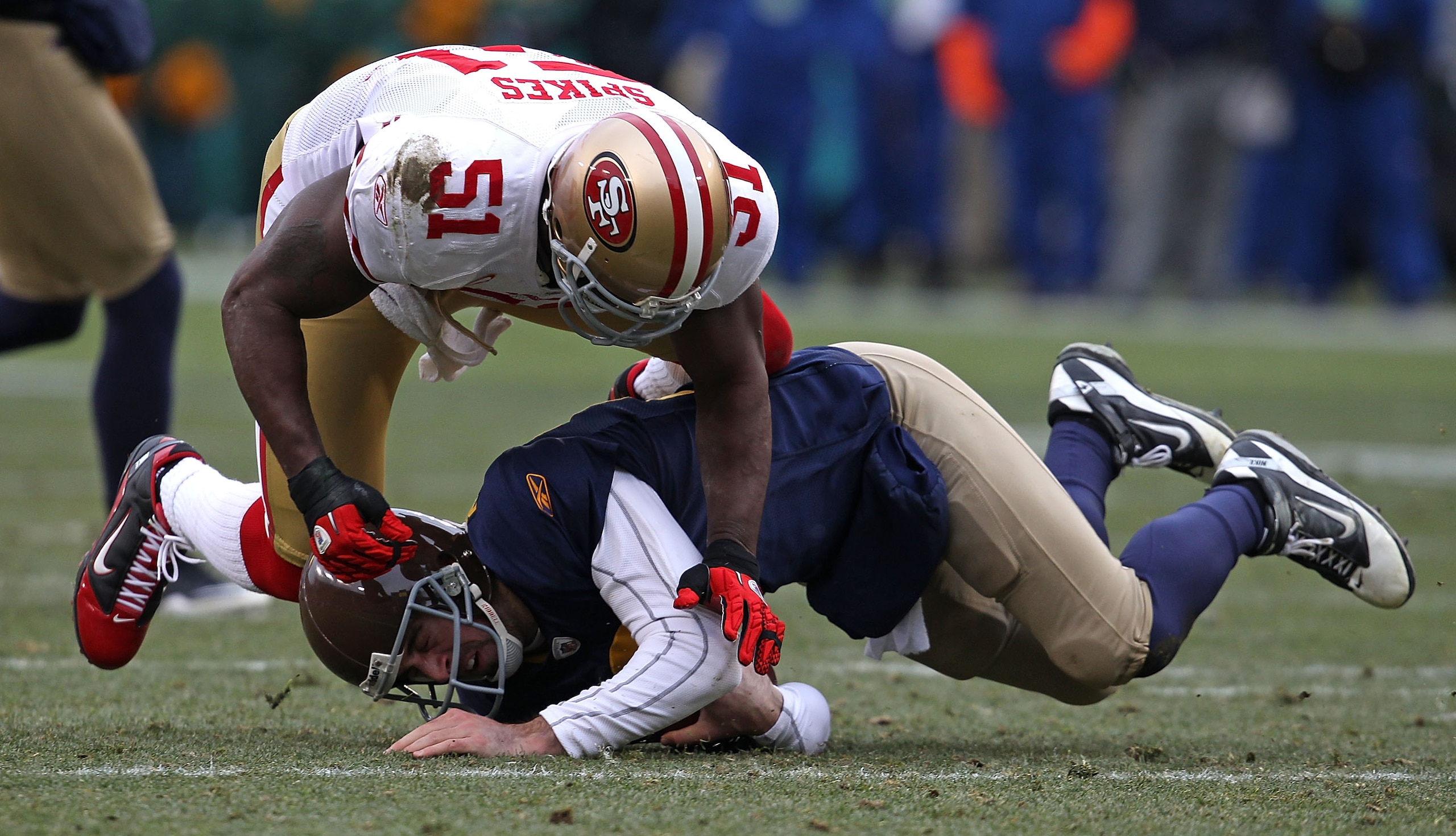 GREEN BAY, WI - DECEMBER 05: Takeo Spikes #51 of the San Francisco 49ers hits Aaron Rodgers #12 of the Green Bay Packers at Lambeau Field on December 5, 2010 in Green Bay, Wisconsin. The Packers defeated the 49ers 34-16. (Photo by Jonathan Daniel/Getty Im