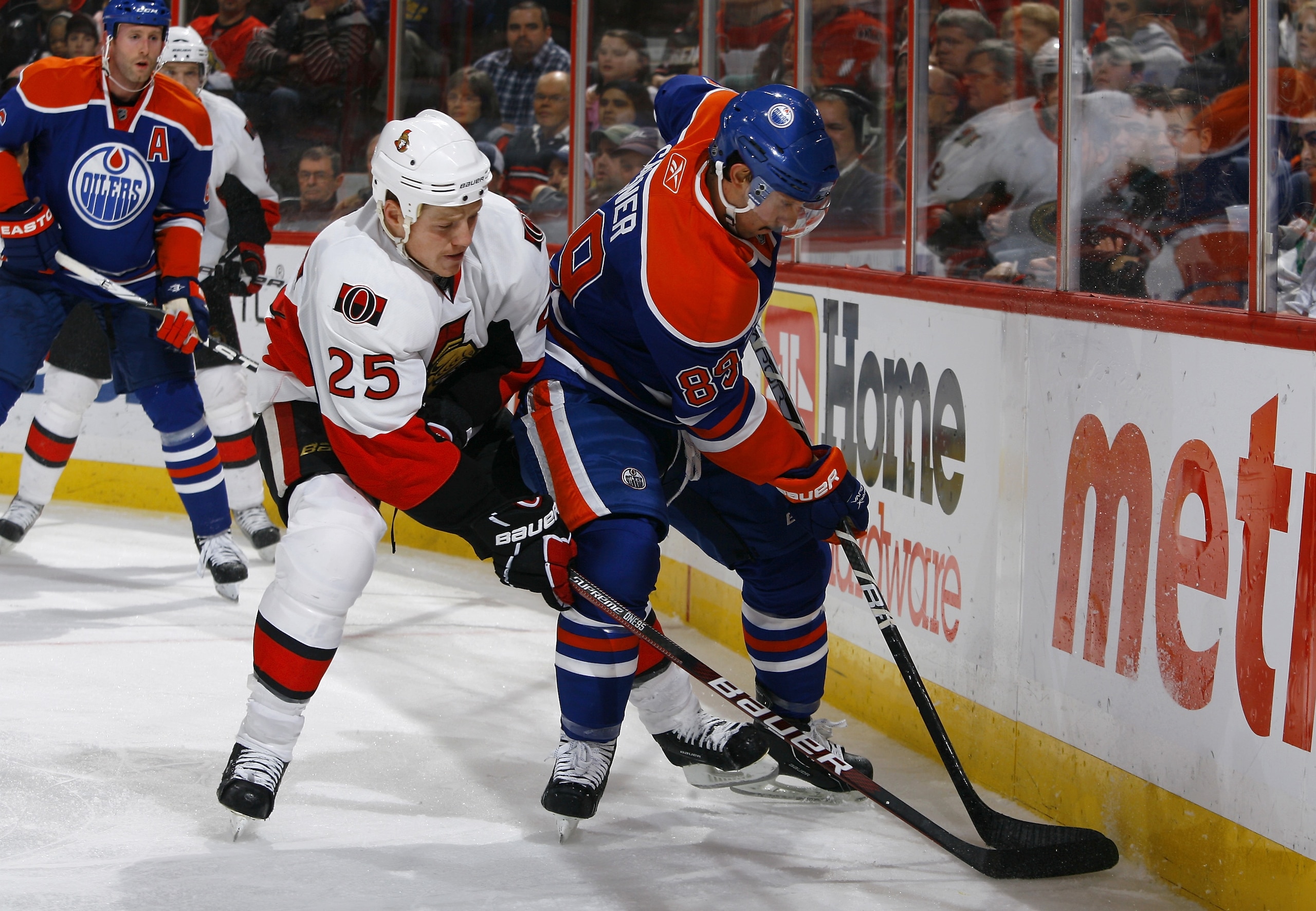 OTTAWA, ON - NOVEMBER 29:  Chris Neil #25 of the Ottawa Senators battles for the puck along the end boards with Sam Gagner #89 of the Edmonton Oilers during a game at Scotiabank Place on November 29, 2010 in Ottawa, Ontario, Canada.  (Photo by Phillip Mac