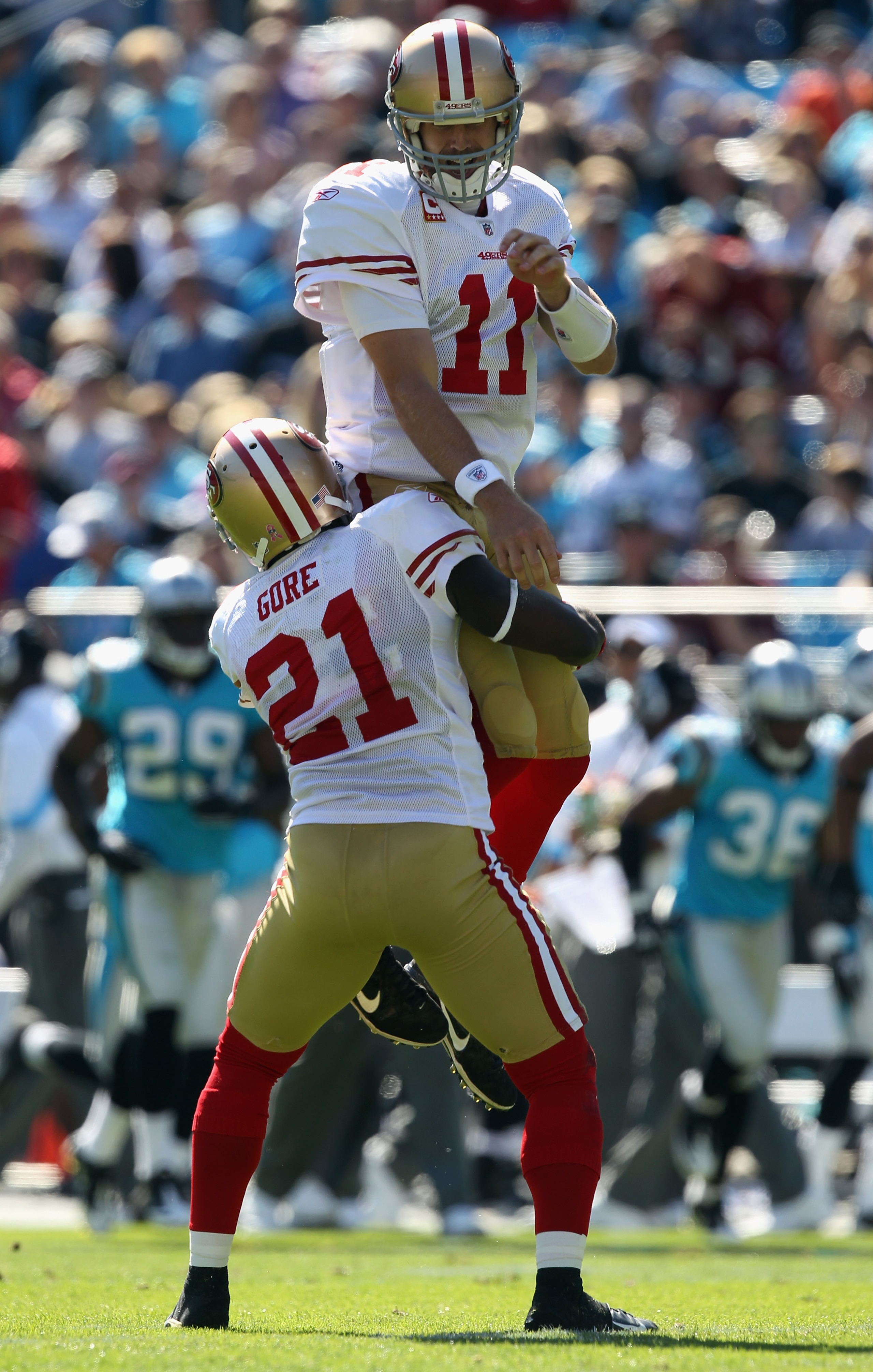 CHARLOTTE, NC - OCTOBER 24:  Frank Gore #21 of the San Francisco 49ers holds up his teammate Alex Smith #11 after a touchdown against the Carolina Panthers during their game at Bank of America Stadium on October 24, 2010 in Charlotte, North Carolina.  (Ph