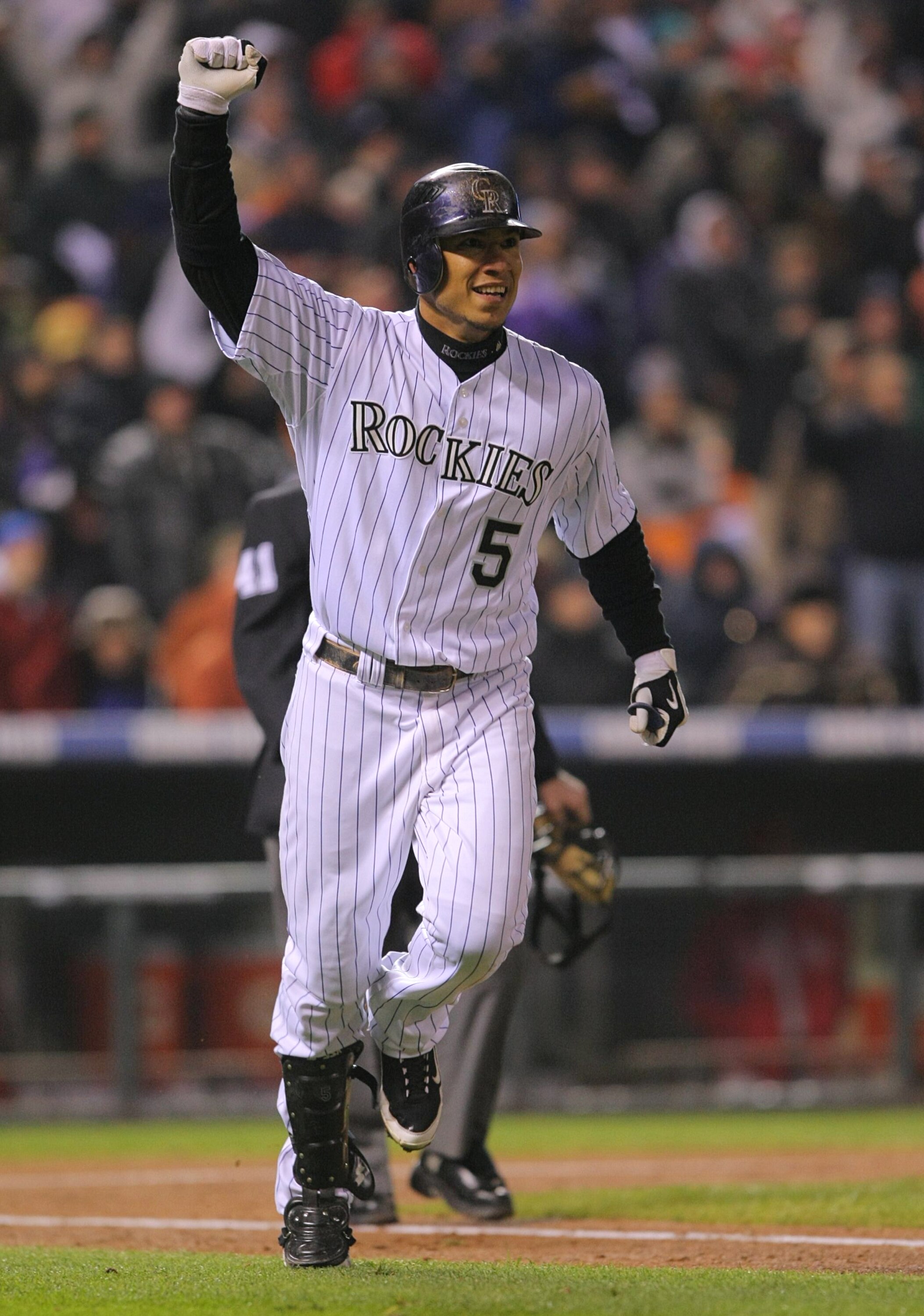 DENVER - OCTOBER 11:  Carlos Gonzalez #5 of the Colorado Rockies celebrates after hitting a solo home run against the Philadelphia Phillies in the bottom of the fourth inning in Game Three of the NLDS during the 2009 MLB Playoffs at Coors Field on October