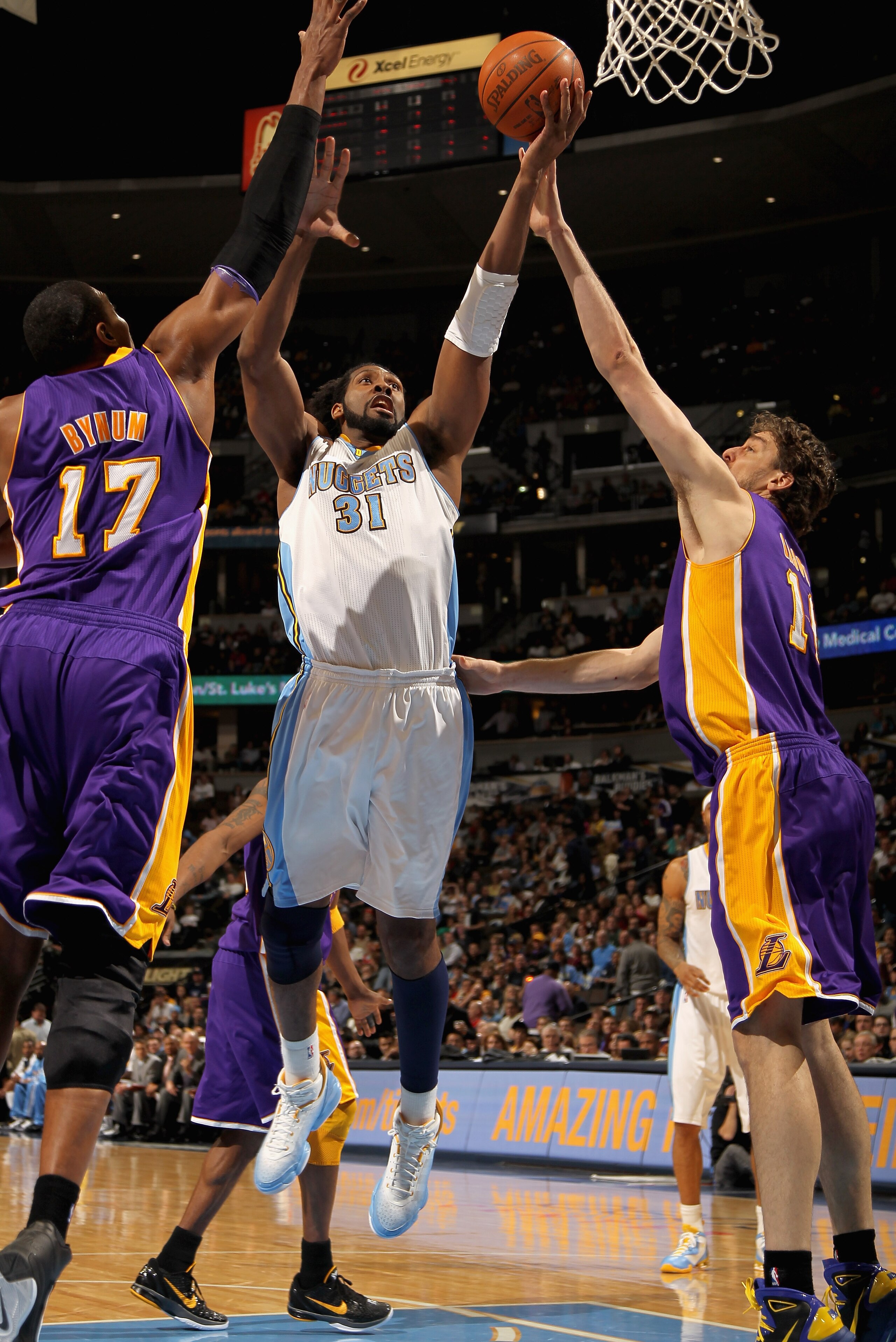 DENVER, CO - JANUARY 21:  Nene #31 of the Denver Nuggets puts up a shot between Andrew Bynum #17 and Pau Gasol #16 of the Los Angeles Lakers at the Pepsi Center on January 21, 2011 in Denver, Colorado. The Lakers defeated the Nuggets 107-97. NOTE TO USER: