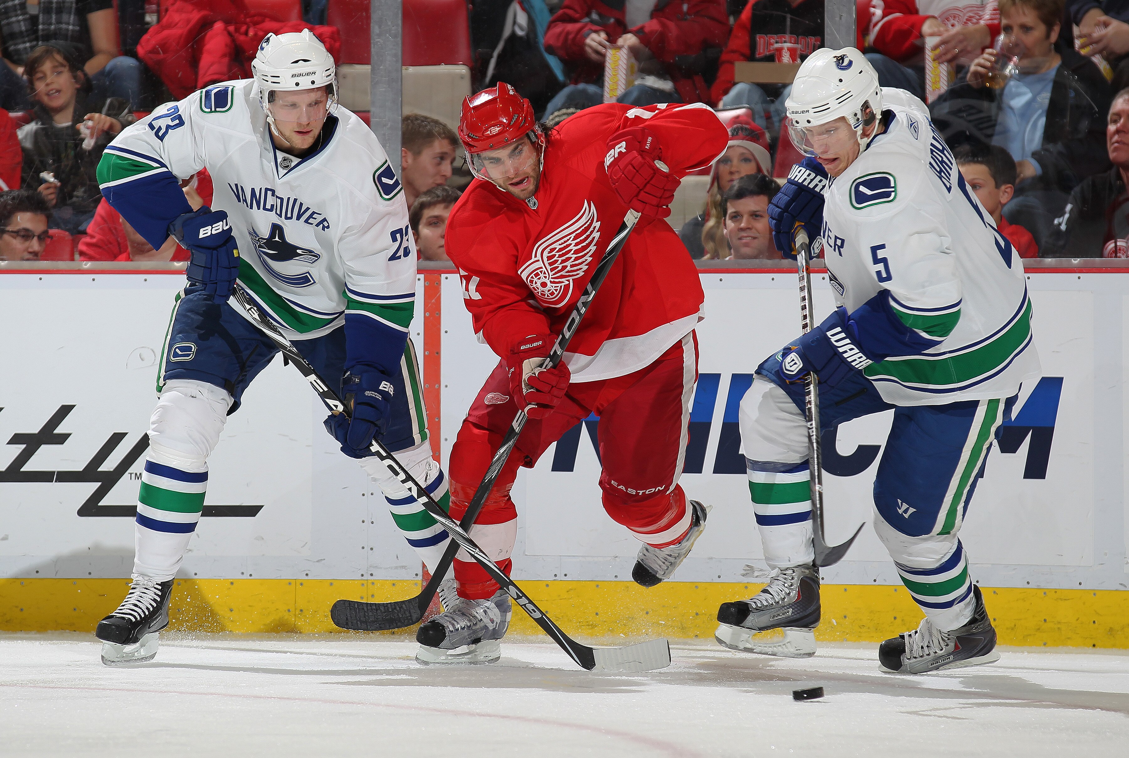 DETROIT, MI - DECEMBER 22:  Patrick Eaves #17 of the Detroit Red Wings chases after a puck between Alexander Edler #23 and Christian Ehrhoff #5 of the Vancouver Canucks in a game on December 22, 2010 at the Joe Louis Arena in Detroit, Michigan. The Wings