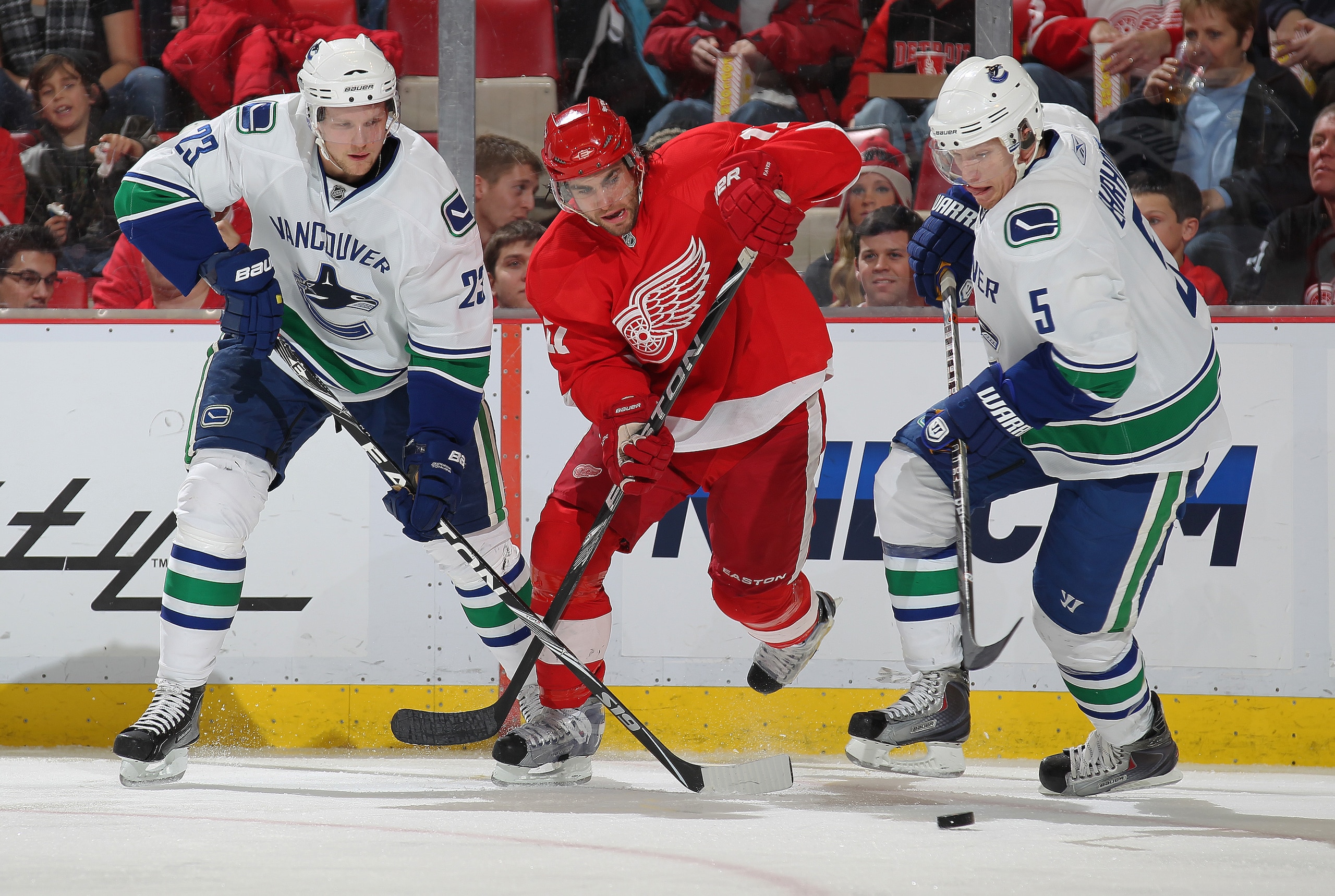 DETROIT, MI - DECEMBER 22:  Patrick Eaves #17 of the Detroit Red Wings chases after a puck between Alexander Edler #23 and Christian Ehrhoff #5 of the Vancouver Canucks in a game on December 22, 2010 at the Joe Louis Arena in Detroit, Michigan. The Wings