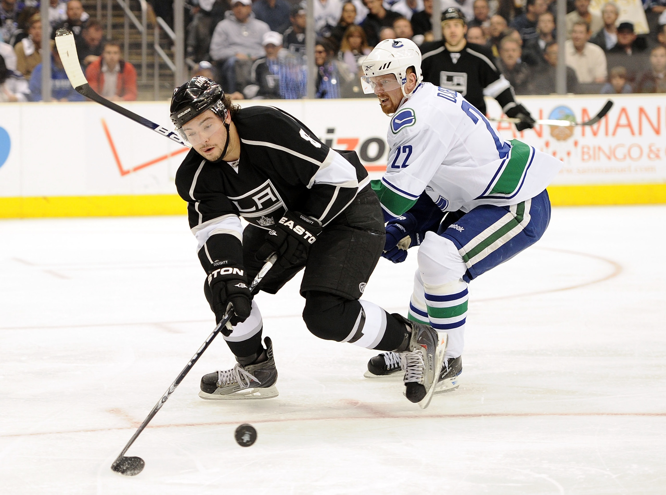 LOS ANGELES, CA - APRIL 21:  Drew Doughty #8 of the Los Angeles Kings clears the puck in front of Daniel Sedin #22 of the Vancouver Canucks during the first period in game four of the Western Conference Quarter-final at Staples Center on April 21, 2010 in