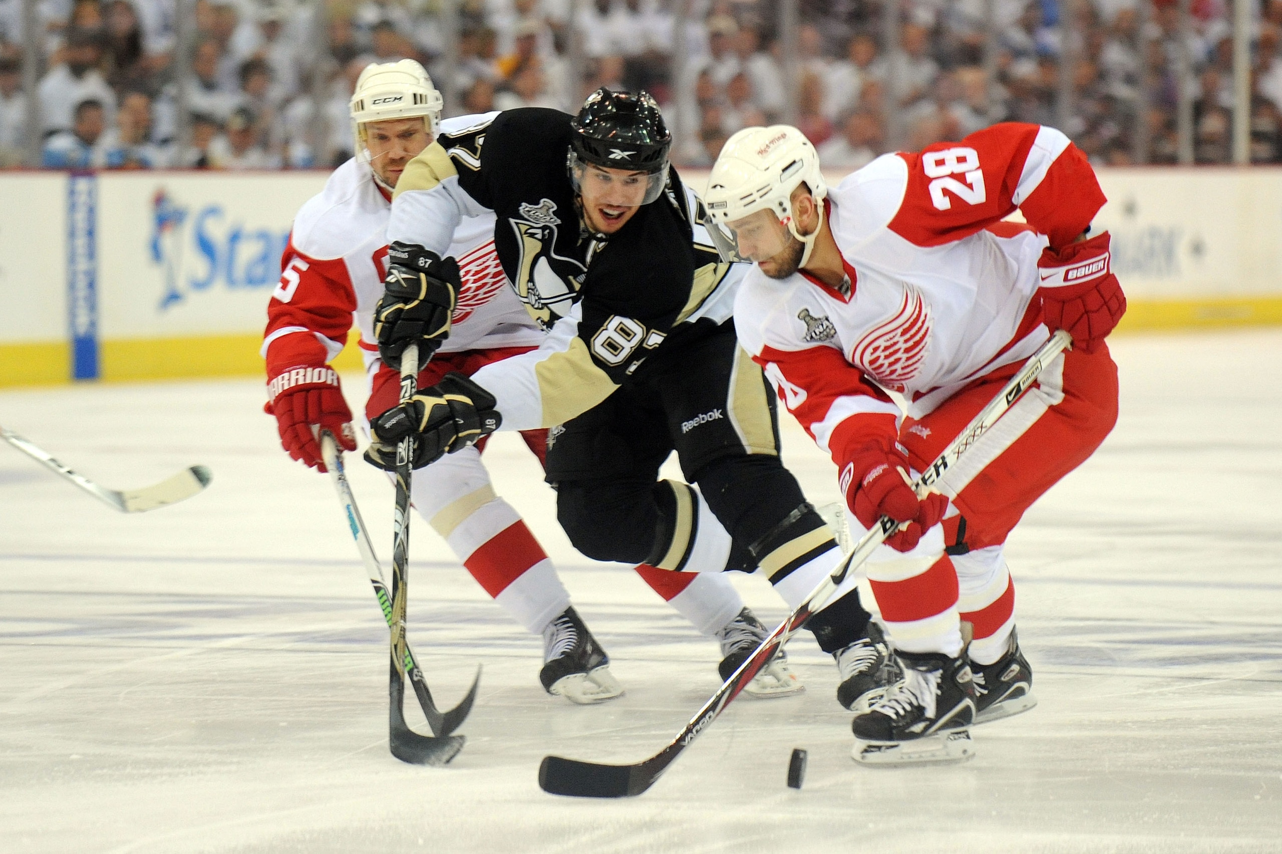 PITTSBURGH - JUNE 09:  Nicklas Lidstrom #5 and Brian Rafalski #28 of the Detroit Red Wings fights for the puck against Sidney Crosby #87 of the Pittsburgh Penguins during Game Six of the NHL Stanley Cup Finals at the Mellon Arena on June 9, 2009 in Pittsb