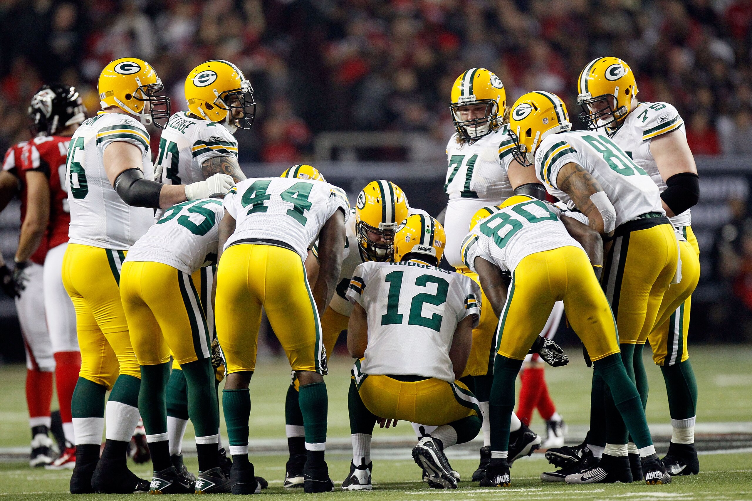 ATLANTA, GA - JANUARY 15:  Quarterback Aaron Rodgers #12 of the Green Bay Packers calls a play in the offensive huddle against the Atlanta Falcons during their 2011 NFC divisional playoff game at Georgia Dome on January 15, 2011 in Atlanta, Georgia. The P