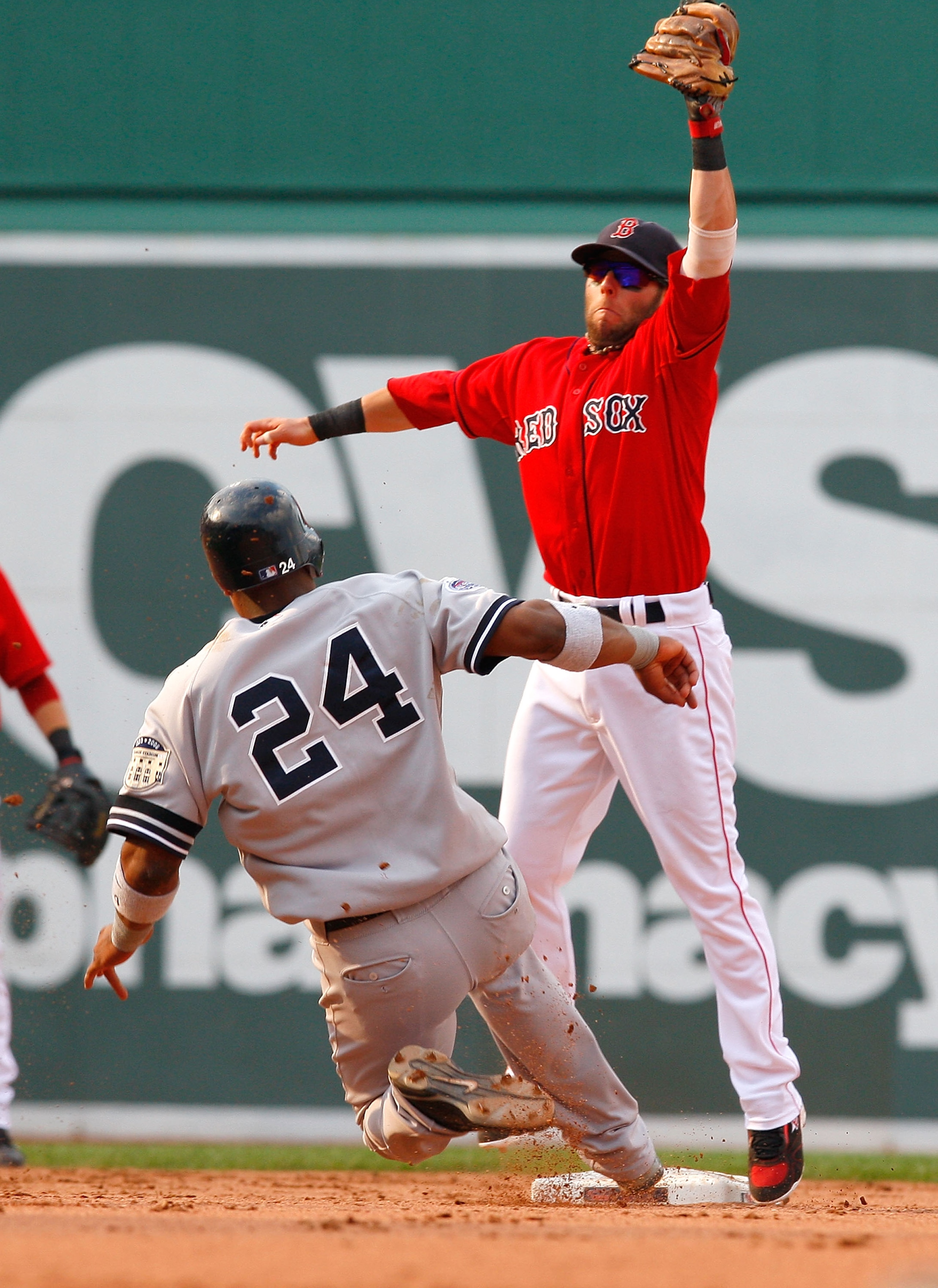 BOSTON - JULY 26: Robinson Cano #24 of the New York Yankees starts a slide into second as Dustin Pedroia #15 of the Boston Red Sox leaps for a throw at Fenway Park on July 26, 2008 in Boston, Massachusetts.  Cano was out on the play. (Photo by Jim Rogash/