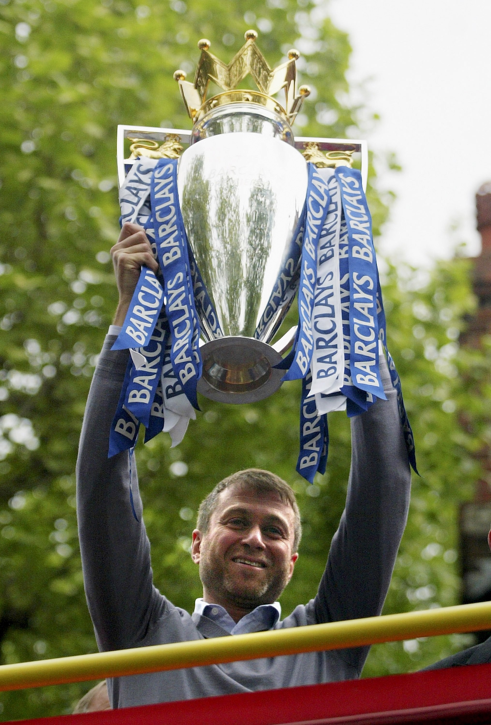 LONDON - MAY 14:  Chelsea owner, Roman Abramovich shows the Premiership Trophy to the fans on the open-topped bus parade of the Barclays Premiership trophy and the FA Community Shield as they make their way down New King's Road on the Chelsea Football Clu