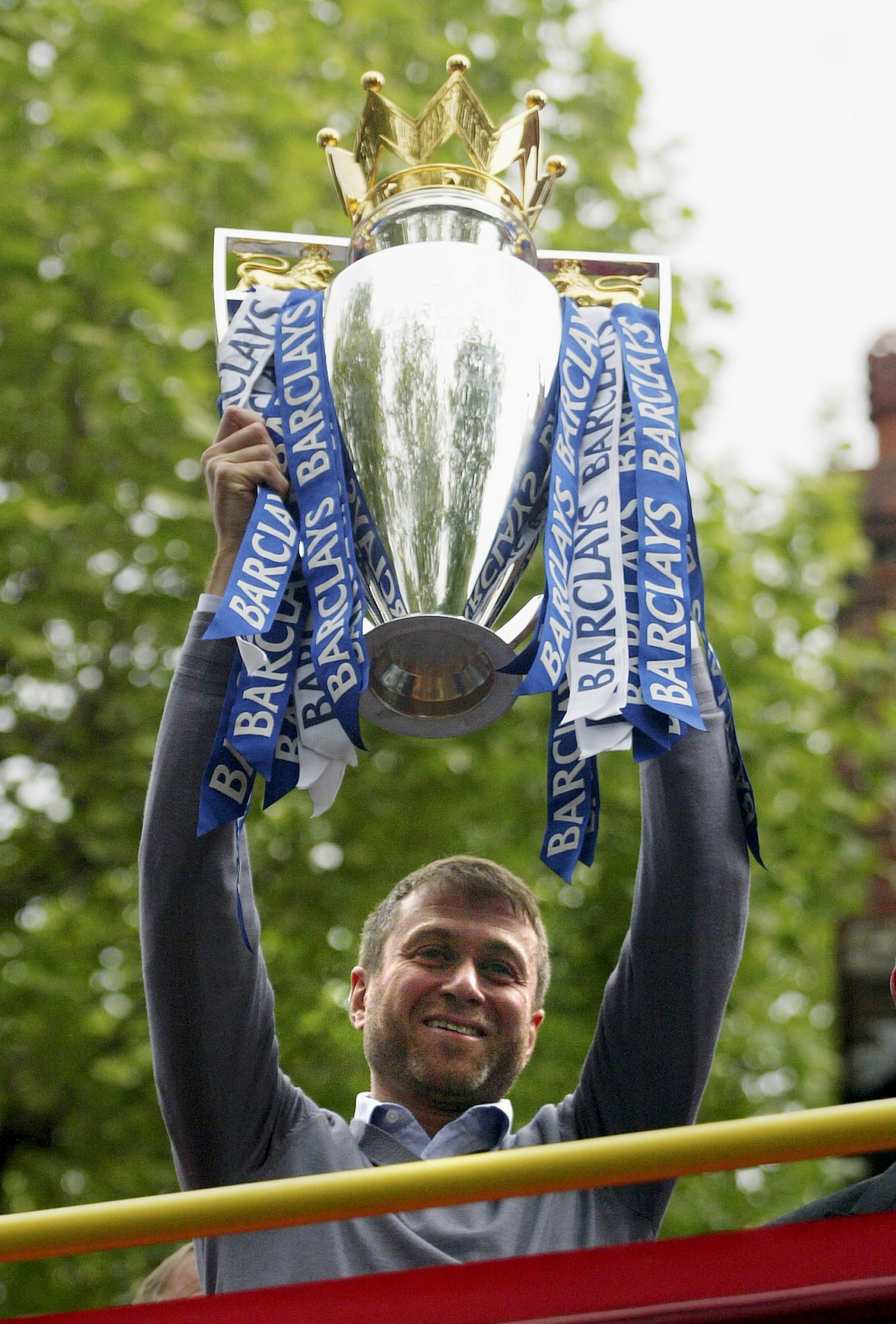 LONDON - MAY 14:  Chelsea owner, Roman Abramovich shows the Premiership Trophy to the fans on the open-topped bus parade of the Barclays Premiership trophy and the FA Community Shield as they make their way down New King's Road on the Chelsea Football Clu