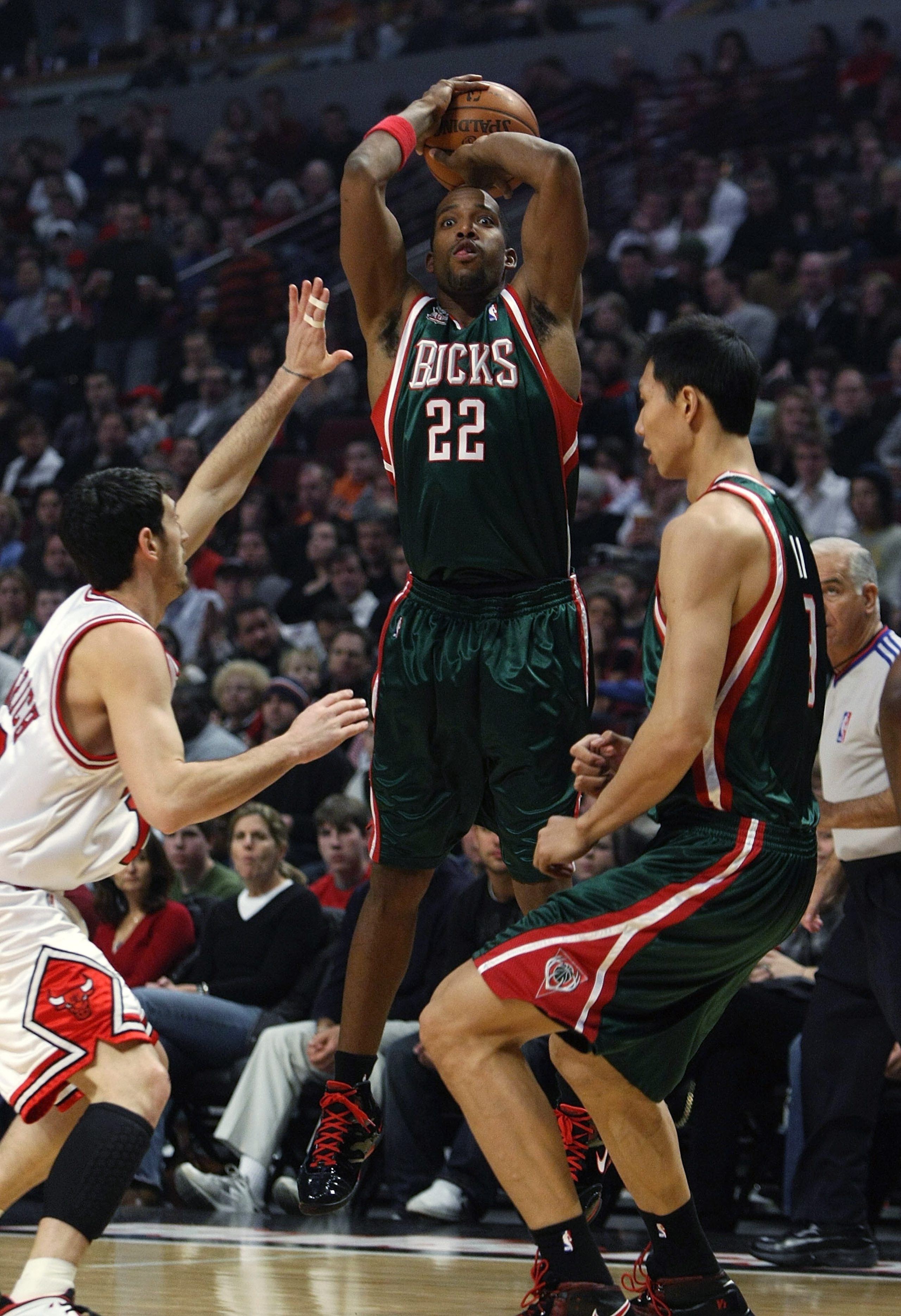 CHICAGO - DECEMBER 28: Michael Redd #22 of the Milwaukee Bucks puts up a shot over teammate Yi Jianlian #9 and Kirk Hinrich #12 of the Chicago Bulls on December 28, 2007 at the United Center in Chicago, Illinois. NOTE TO USER: User expressly acknowledges