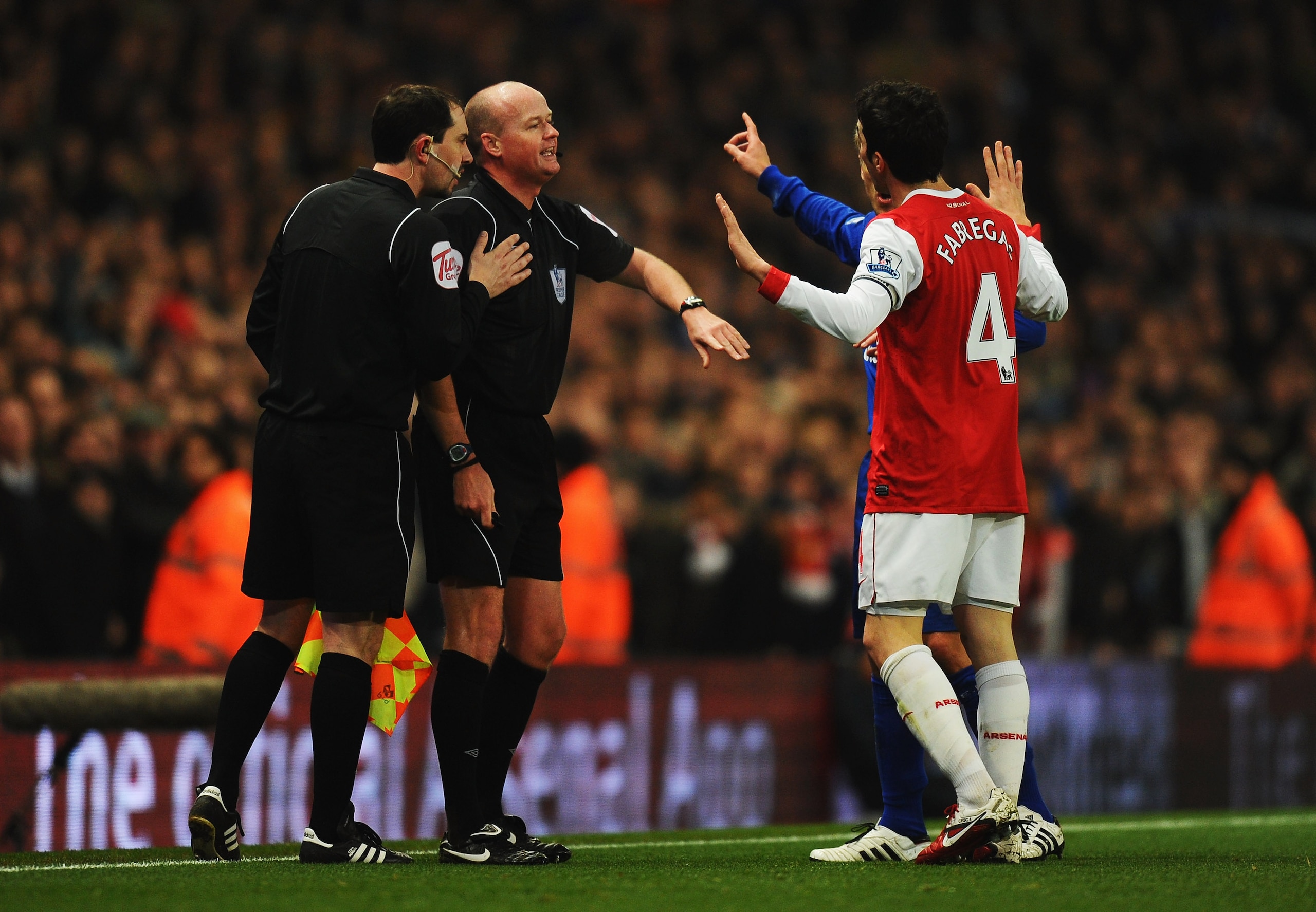 LONDON, ENGLAND - FEBRUARY 01:  Referee Lee Mason ushers away Cesc Fabregas of Arsenal and Phil Neville of Everton as they appeal to the assistant referee during the Barclays Premier League match between Arsenal and Everton at the Emirates Stadium on Febr