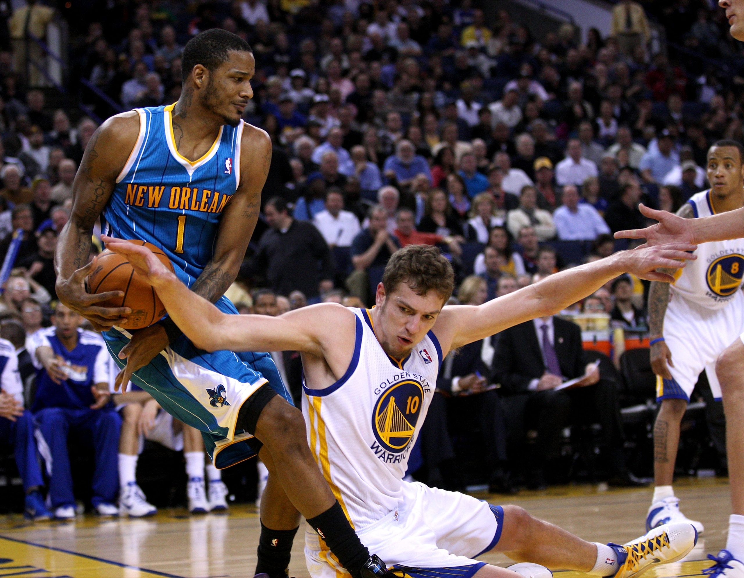 OAKLAND, CA - JANUARY 26:  Trevor Ariza #1 of the New Orleans Hornets and David Lee #10 of the Golden State Warriors go for the ball at Oracle Arena on January 26, 2011 in Oakland, California.  NOTE TO USER: User expressly acknowledges and agrees that, by