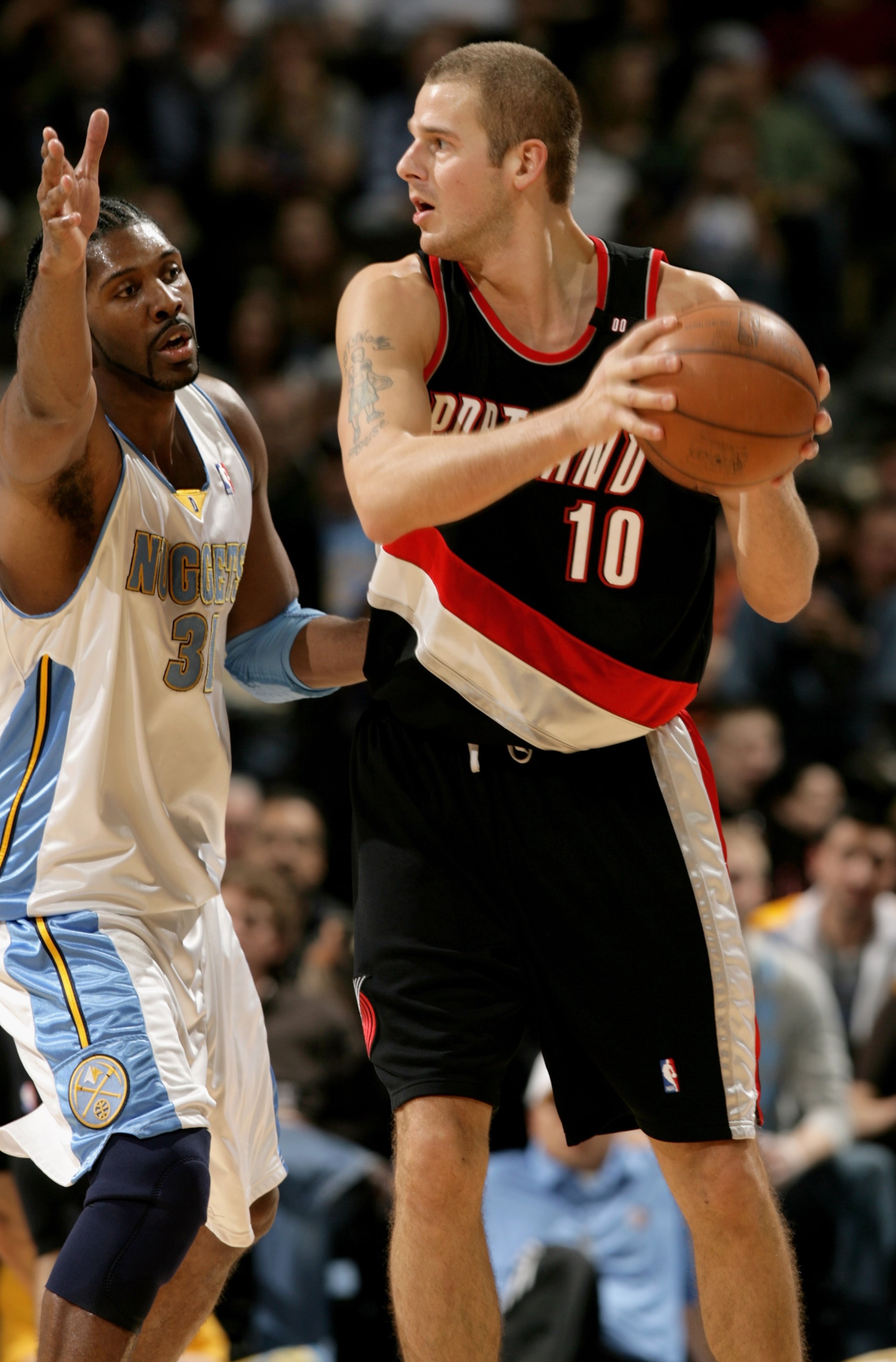 DENVER - MARCH 05:  Joel Przybilla #10 of the Portland Trail Blazers controls the ball against the defense of Nene #31 of the Denver Nuggets during NBA action at the Pepsi Center on March 5, 2009 in Denver, Colorado. The Nuggets defeated the Trail Blazers