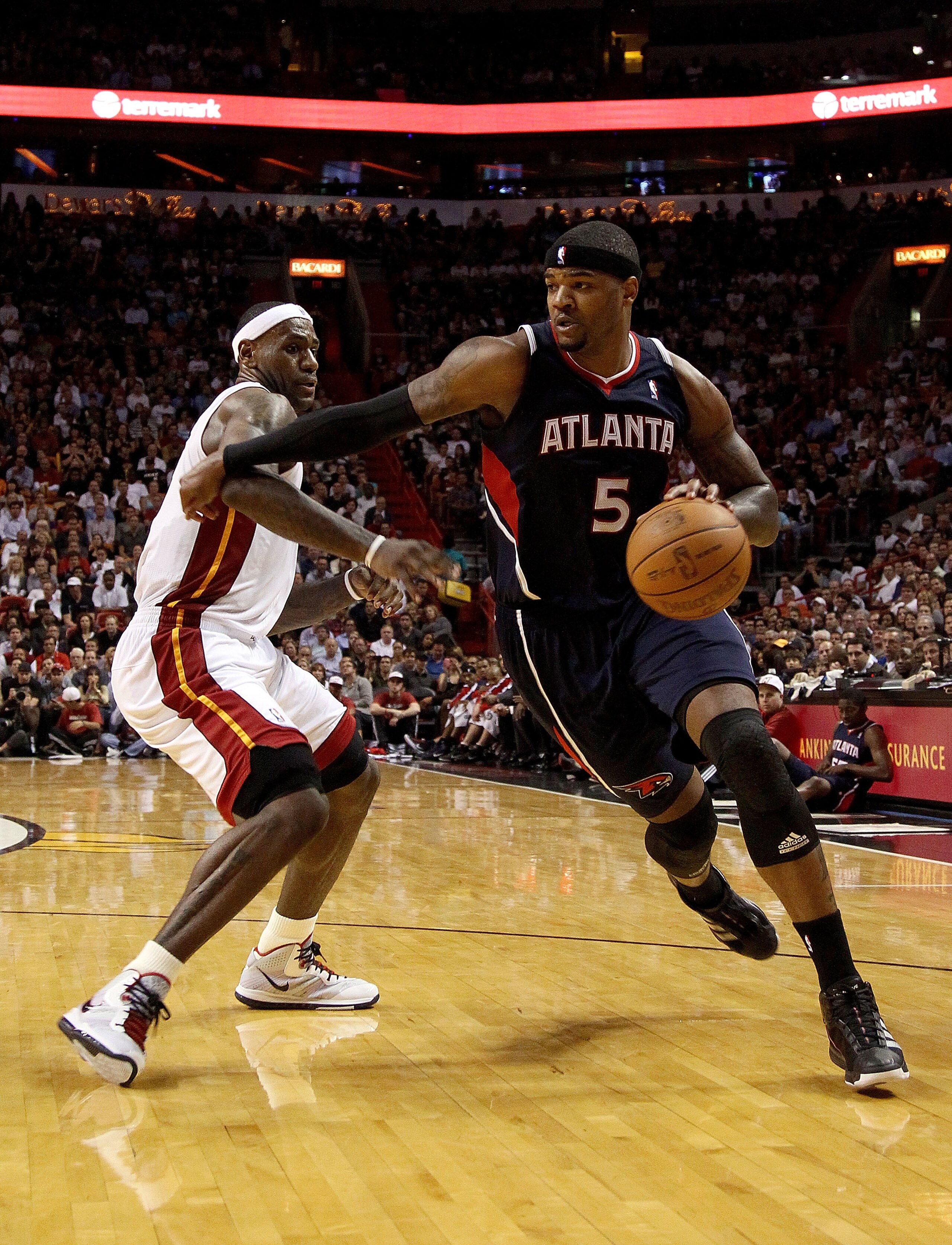 MIAMI, FL - JANUARY 18: Josh Smith #5 of the Atlanta Hawks drives past LeBron James #6 of the Miami Heat during a game at American Airlines Arena on January 18, 2011 in Miami, Florida. NOTE TO USER: User expressly acknowledges and agrees that, by download