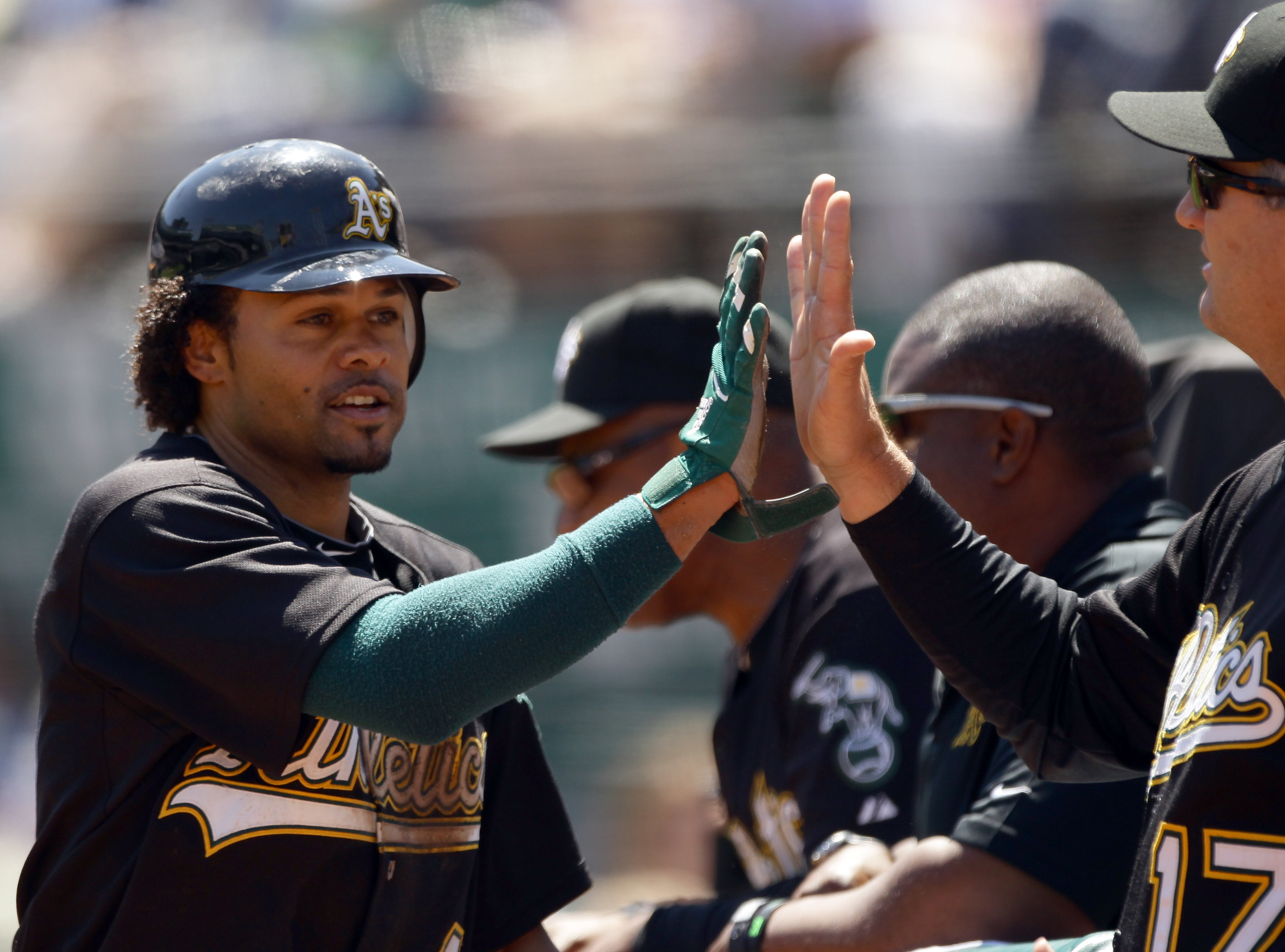 OAKLAND, CA - AUGUST 18:   Coco Crisp #4 of the Oakland Athletics is congratulated by teammates after he scored on a  Kurt Suzuki ground out in the first inning of their game against the Toronto Blue Jays at the Oakland-Alameda County Coliseum on August 1