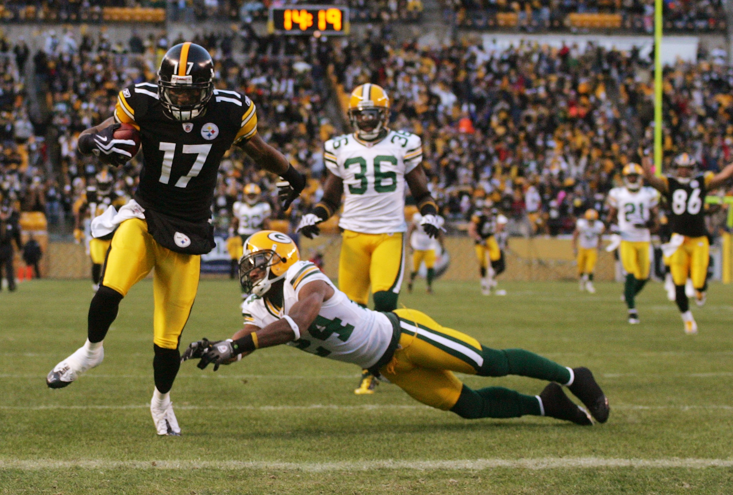 PITTSBURGH - DECEMBER 20: Mike Wallace #17 of the Pittsburgh Steelers runs for a touchdown as Jarrett Bush #24 of the Green Bay Packers attempts to tackle in the first quarter during the game on December 20, 2009 at Heinz Field in Pittsburgh, Pennsylvani PITTSBURGH - DECEMBER 20: Mike Wallace #17 of the Pittsburgh Steelers runs for a touchdown as Jarrett Bush #24 of the Green Bay Packers attempts to tackle in the first quarter during the game on December 20, 2009 at Heinz Field in Pittsburgh, Pennsylvani