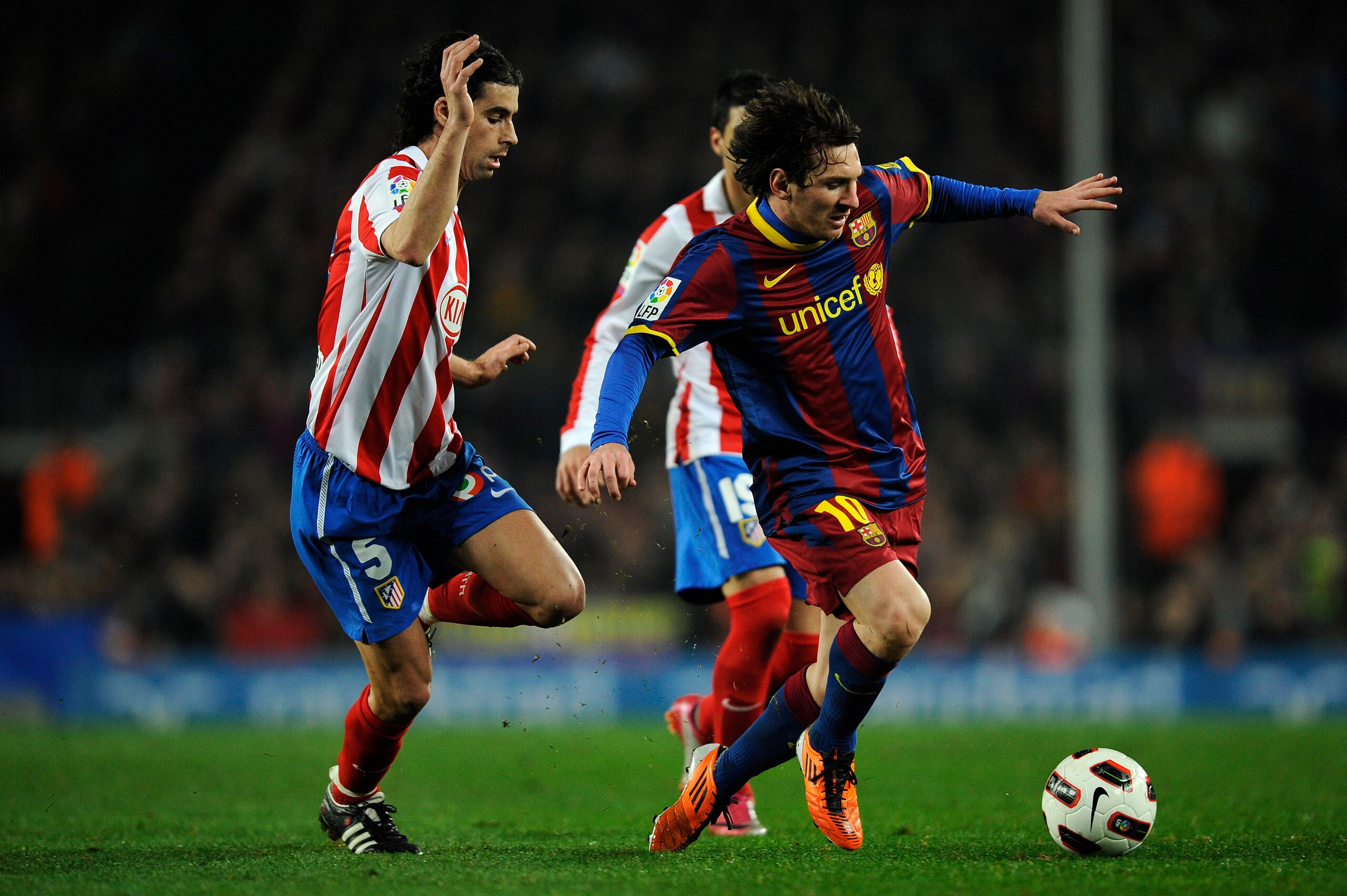BARCELONA, SPAIN - FEBRUARY 05:  Lionel Messi of Barcelona (R) is chased by Tiago Mendes of Atletico Madrid during the La Liga match between Barcelona and Atletico de Madrid at Camp Nou on February 5, 2011 in Barcelona, Spain. Barcelona won 3-0.  (Photo b