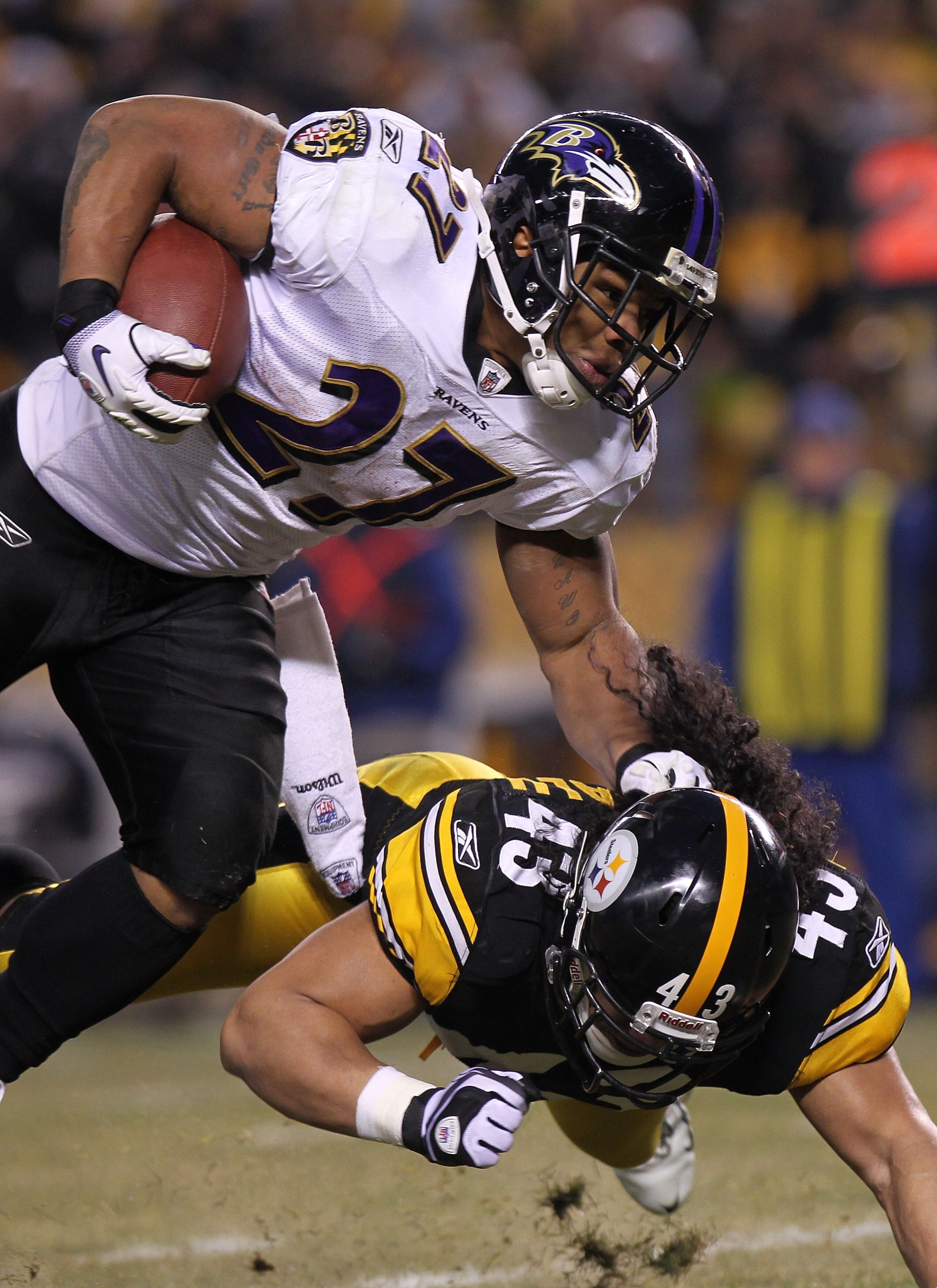 PITTSBURGH, PA - JANUARY 15:  Running back Ray Rice #27 of the Baltimore Ravens runs with the ball after being hit by safety Troy Polamalu #43 of the Pittsburgh Steelers in the AFC Divisional Playoff Game at Heinz Field on January 15, 2011 in Pittsburgh,