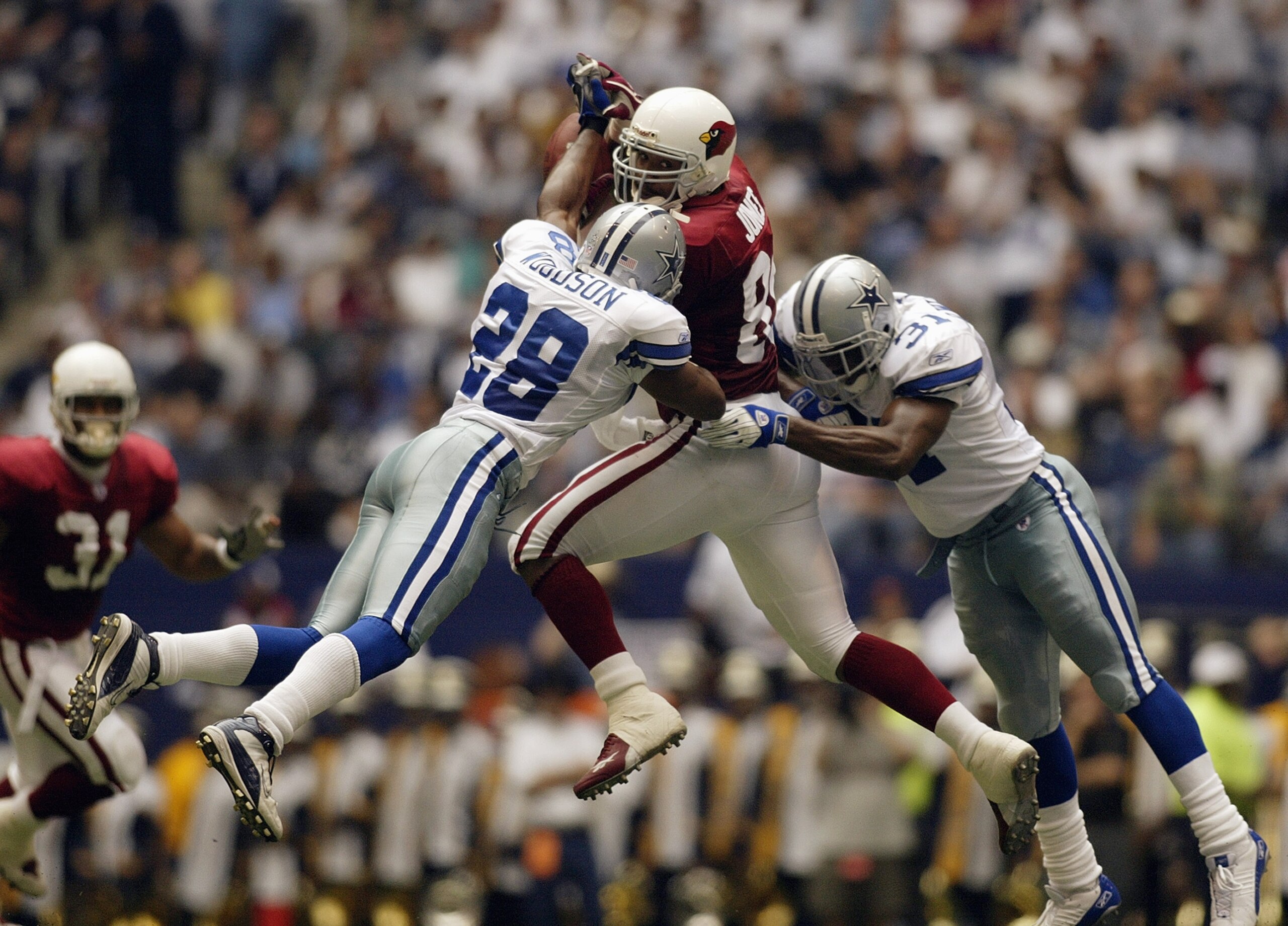 IRVING, TX - OCTOBER 5:  Darren Woodson #28 and Roy Williams #31 of the Dallas Cowboys tackle tight end Freddie Jones #85 of the Arizona Cardinals on the incomplete pass at Texas Stadium on October 5, 2003 in Irving, Texas.  The Cowboys defeated the Cardi
