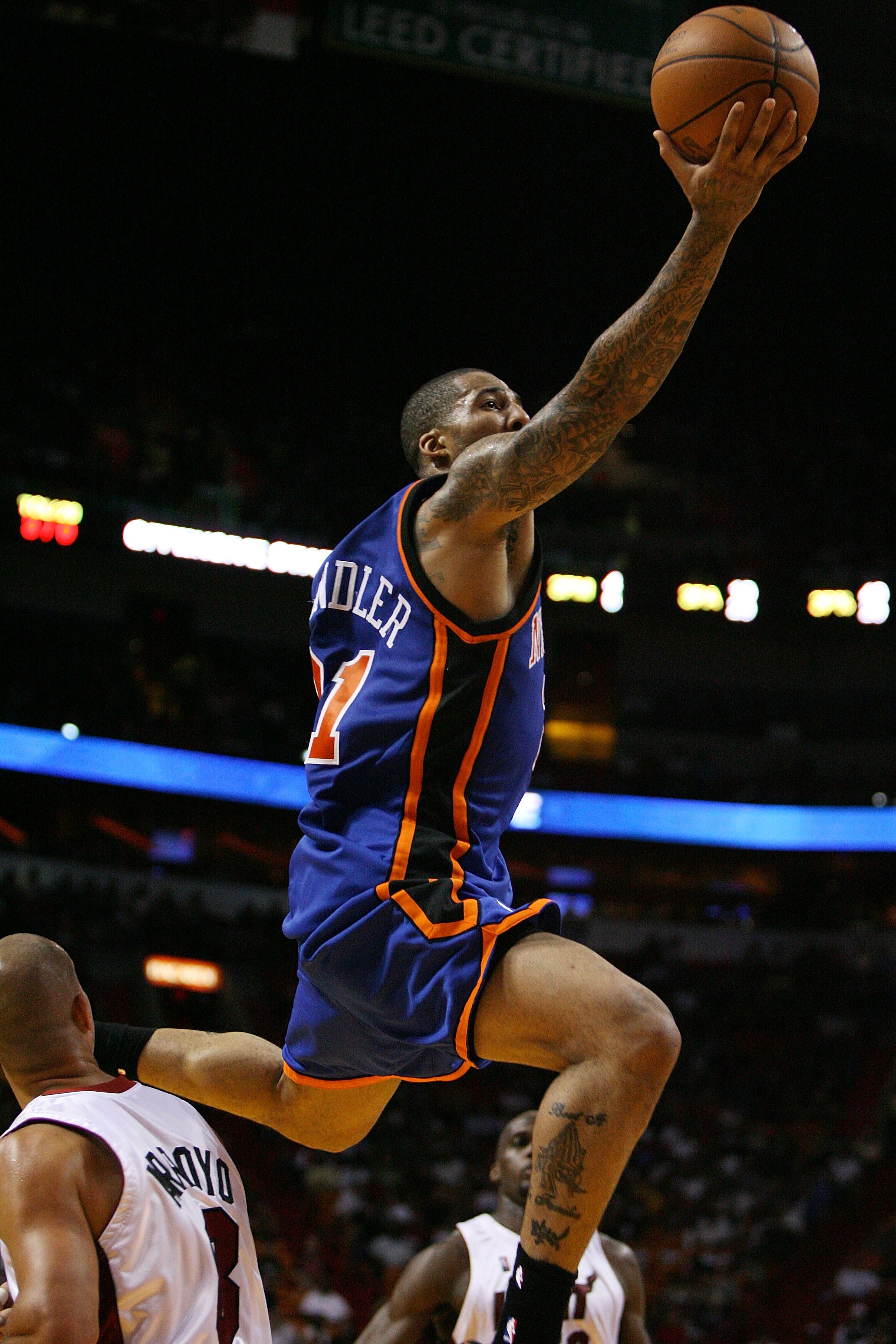 MIAMI - OCTOBER 28:  Wilson Chandler #21 of the New York Knicks jumps over Carlos Arroyo #8 of the Miami Heat at AmericanAirlines Arena on October 28, 2009 in Miami, Florida. The Heat defeated the Knicks 115-93. NOTE TO USER: User expressly acknowledges a