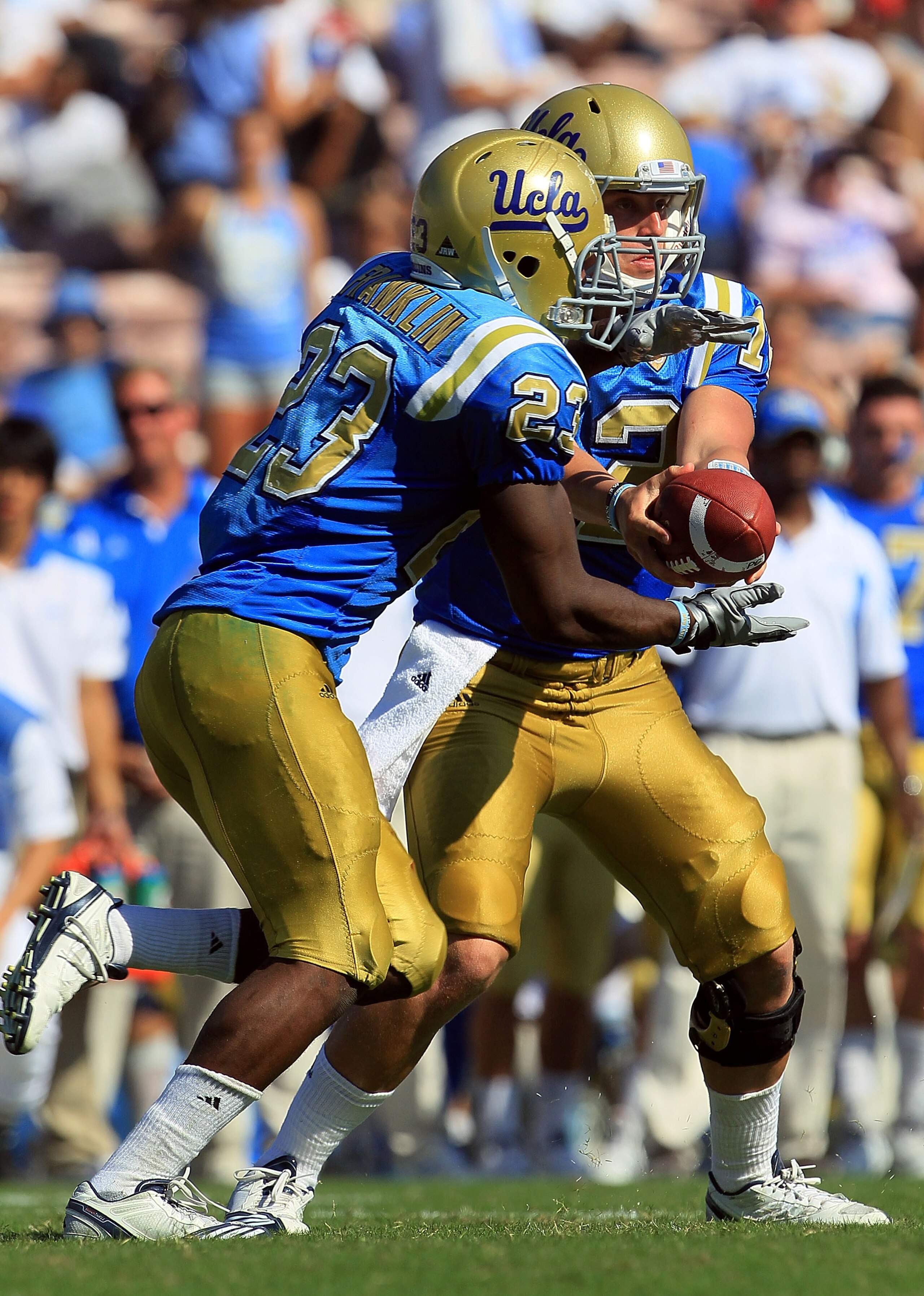 PASADENA, CA - OCTOBER 02:  Quarterback Richard Brehaut #12 of the UCLA Bruins hands off to Johnathan Franklin #23 against the Washington State Cougars during the game at the Rose Bowl on October 2, 2010 in Pasadena, California. UCLA defeated Washington S