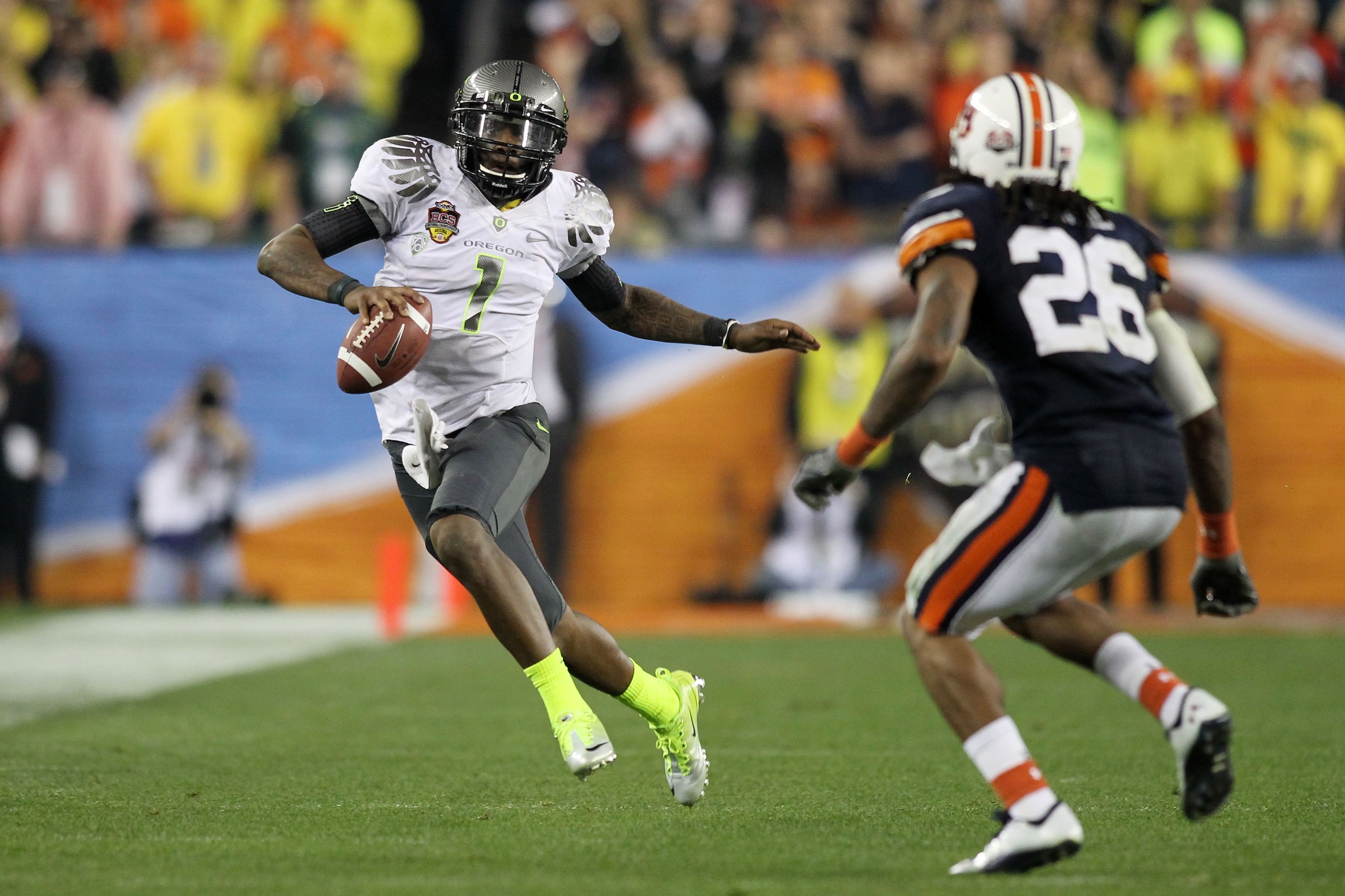 GLENDALE, AZ - JANUARY 10:  Darron Thomas #1 of the Oregon Ducks scrambles against Mike McNeil #26 of the Auburn Tigers during the Tostitos BCS National Championship Game at University of Phoenix Stadium on January 10, 2011 in Glendale, Arizona.  (Photo b