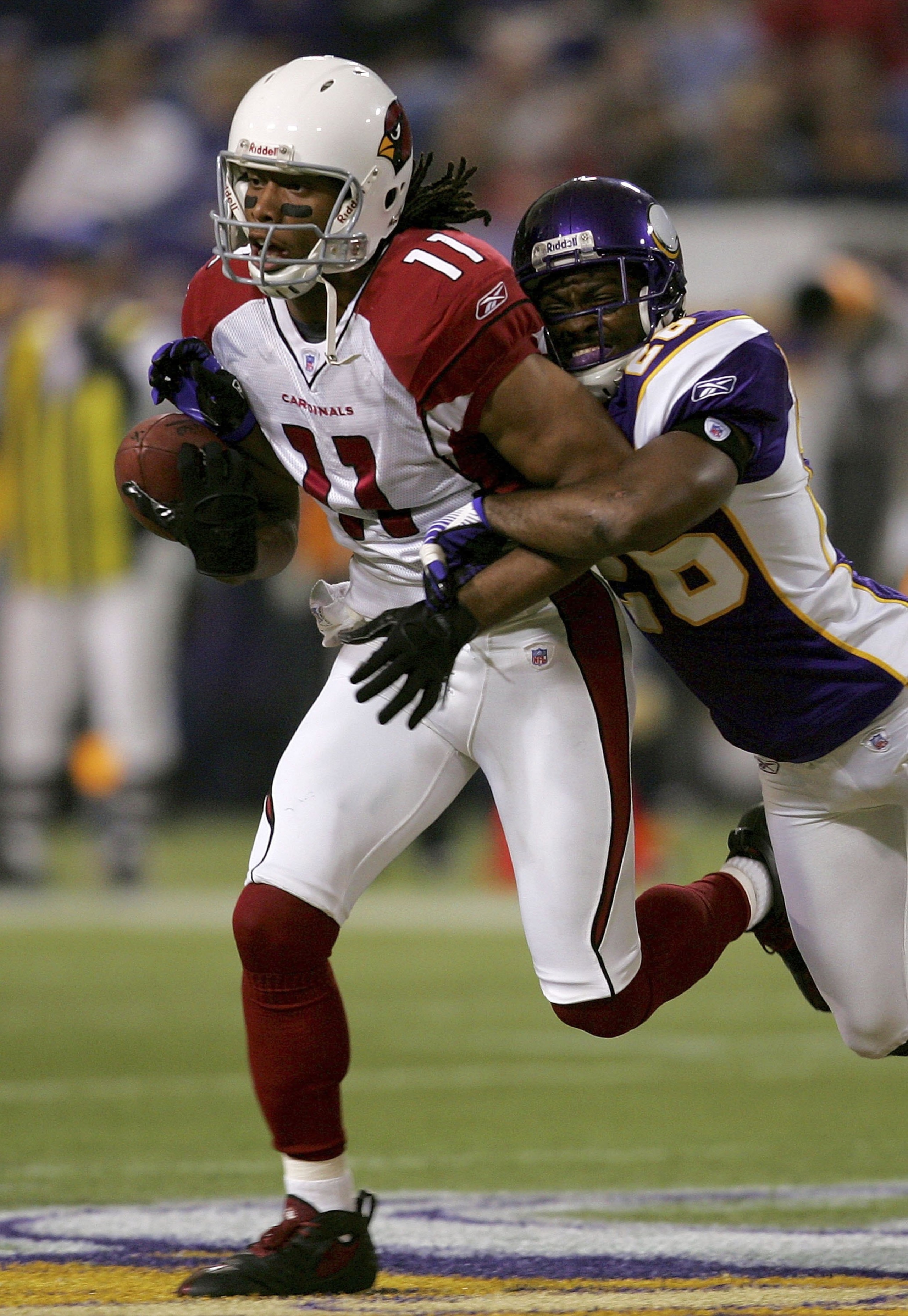 MINNEAPOLIS, MN - NOVEMBER 26: Larry Fitzgerald #11 of the Arizona Cardinals attempts to break free from Antoine Winfield #26 of the Minnesota Vikings at the Hubert H. Humprey Metrodome November 26, 2006 in Minneapolis, Minnesota. (Photo by Matthew Stoc MINNEAPOLIS, MN - NOVEMBER 26: Larry Fitzgerald #11 of the Arizona Cardinals attempts to break free from Antoine Winfield #26 of the Minnesota Vikings at the Hubert H. Humprey Metrodome November 26, 2006 in Minneapolis, Minnesota. (Photo by Matthew Stoc