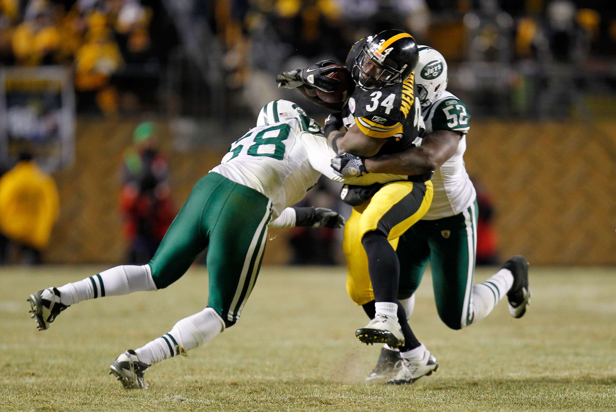 PITTSBURGH, PA - JANUARY 23:  Rashard Mendenhall #34 of the Pittsburgh Steelers is tackled by Josh Mauga #58 and David Harris #52 of the New York Jets during the 2011 AFC Championship game at Heinz Field on January 23, 2011 in Pittsburgh, Pennsylvania.  (