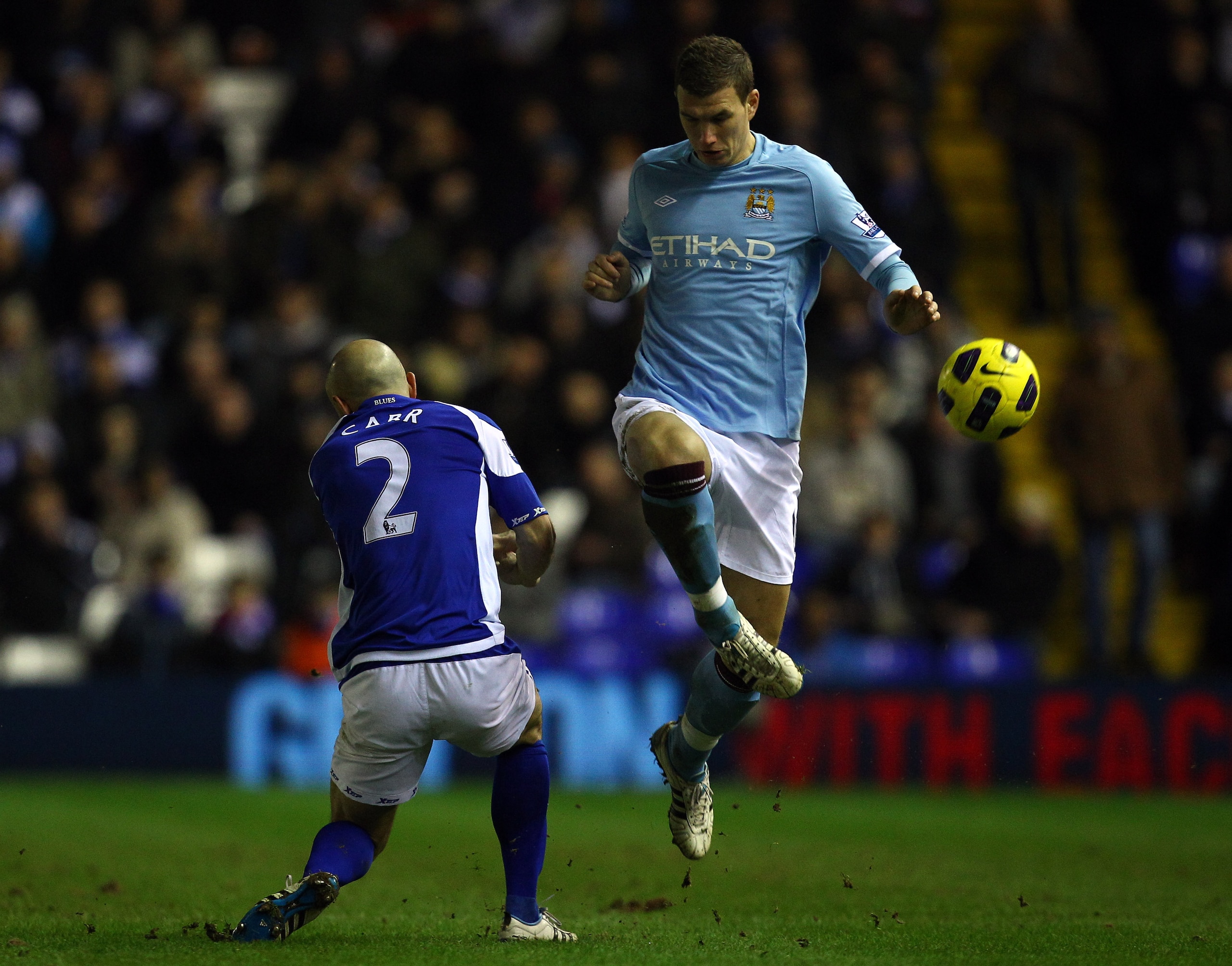 BIRMINGHAM, ENGLAND - FEBRUARY 02:  Edin Dzeko  of Manchester City goes past Stephen Carr of Birmingham during the Barclays premier league match between Birmingham City and Manchester City at St Andrews on February 2, 2011 in Birmingham, England.  (Photo