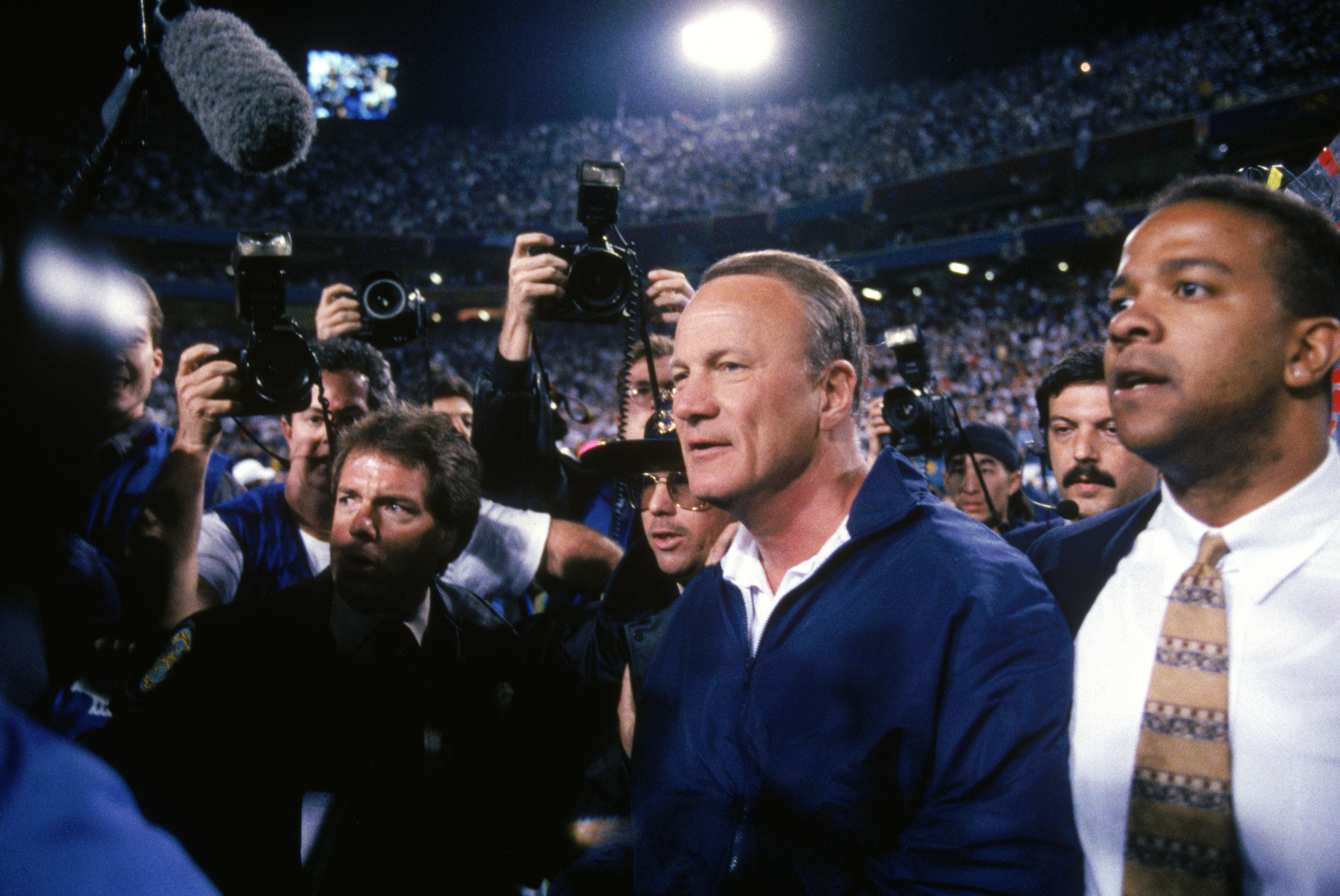 TEMPE, AZ - JANUARY 28:  Head coach Barry Switzer of the Dallas Cowboys gets escorted through the field after the Cowboys victory over the Pittsburgh Steelers in Super Bowl XXX at Sun Devil Stadium on January 28, 1996 in Tempe, Arizona.  The Cowboys won 2