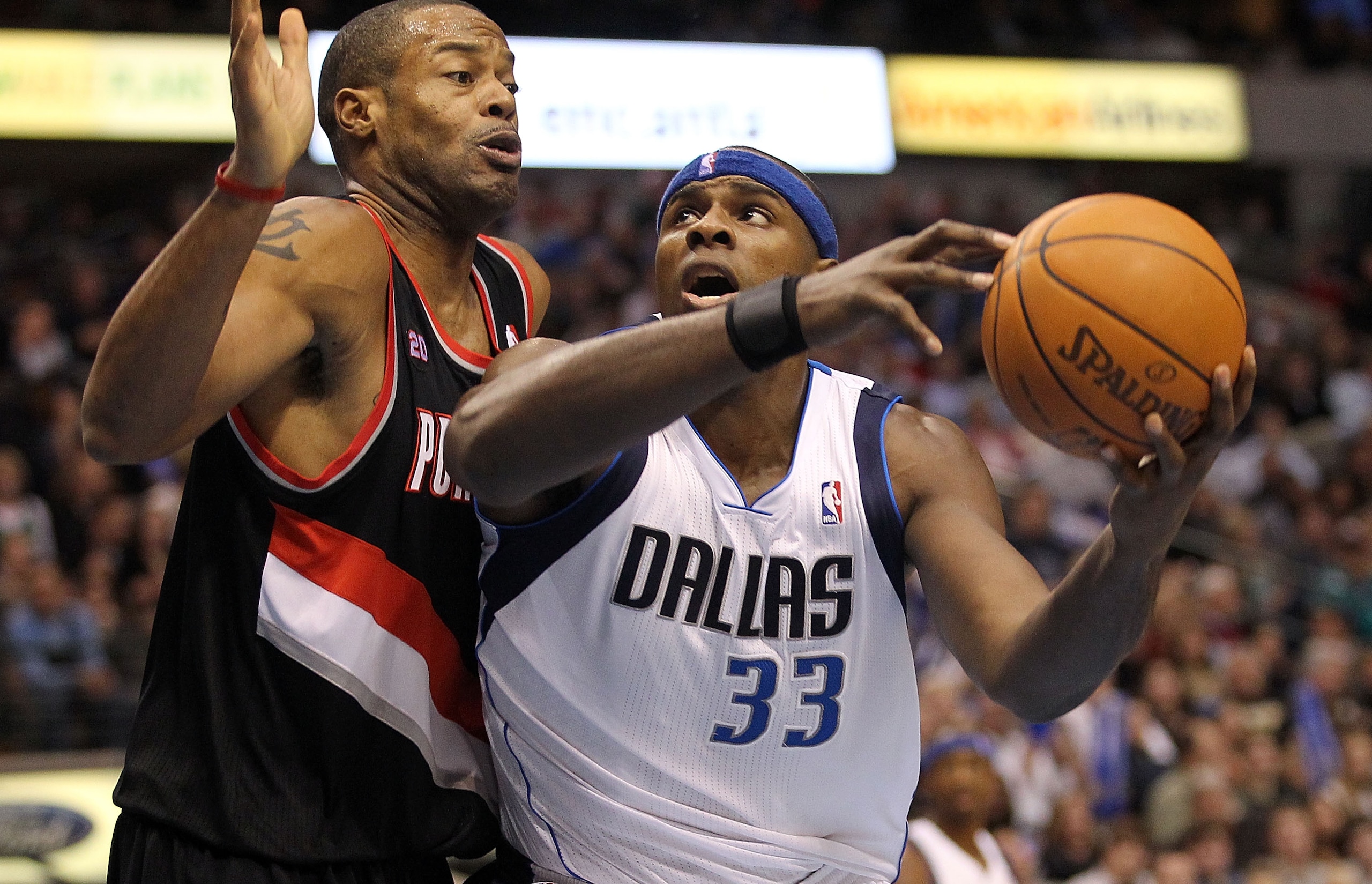 DALLAS, TX - JANUARY 04:  Center Brendan Haywood #33 of the Dallas Mavericks dribbles the ball against Marcus Camby #23 of the Portland Trail Blazers at American Airlines Center on January 4, 2011 in Dallas, Texas.  NOTE TO USER: User expressly acknowledg
