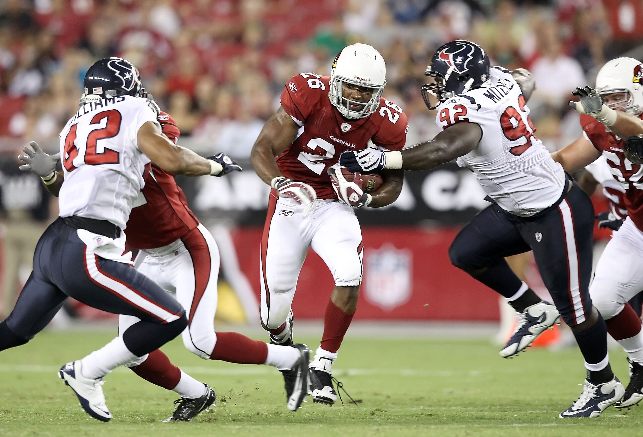 GLENDALE, AZ - AUGUST 14:  Runningback Beanie Wells #26 of the Arizona Cardinals carries the ball for a 10 yard rush past Earl Mitchell #92 of the Houston Texans during preseason NFL game at the University of Phoenix Stadium on August 14, 2010 in Glendale