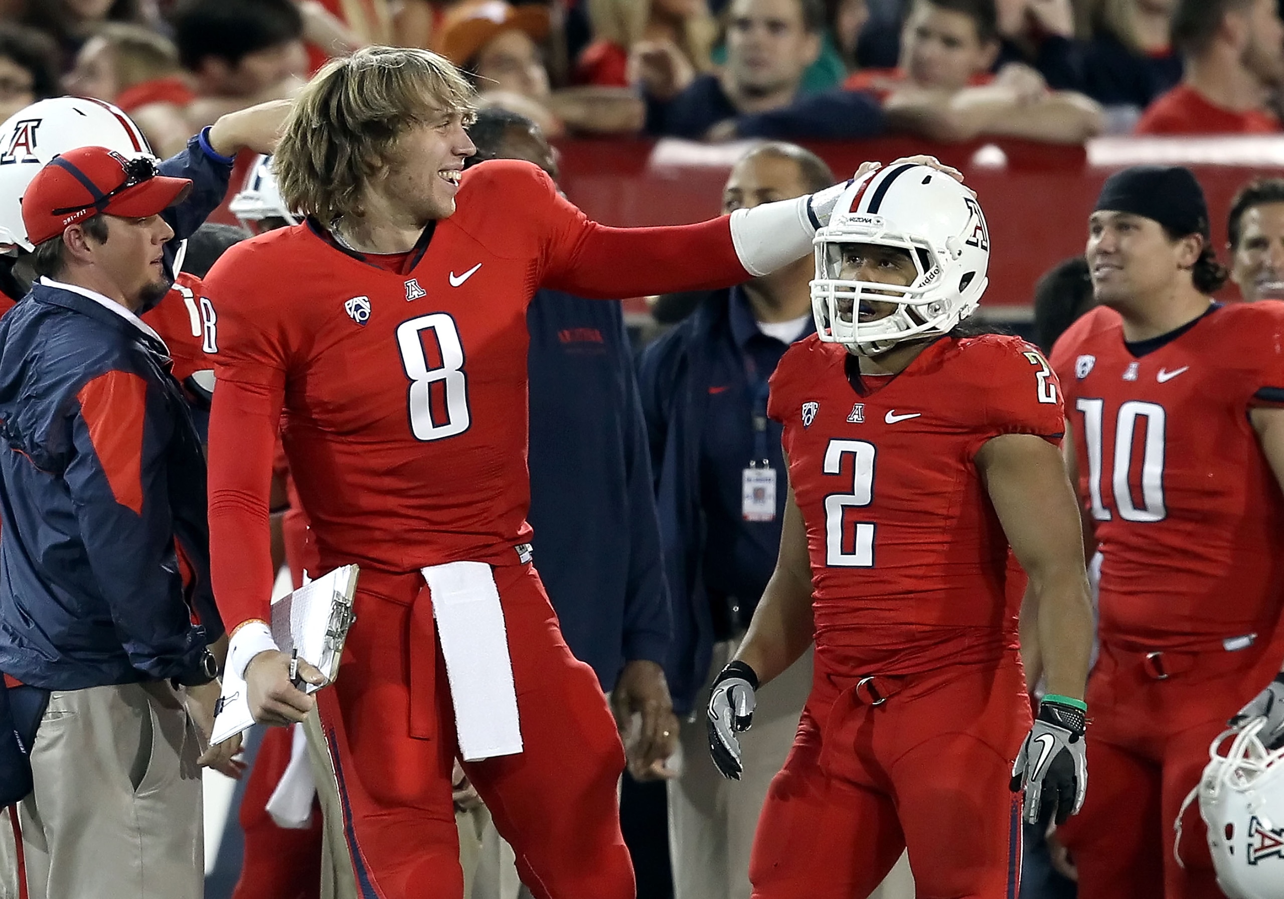 TUCSON, AZ - OCTOBER 23:  Injured quarterback Nick Foles #8 of the Arizona Wildcats congratulates Keola Antolin #2 after Antolin scored a 78 yard rushing touchdown against the Washington Huskies during the second quarter of the college football game at Ar