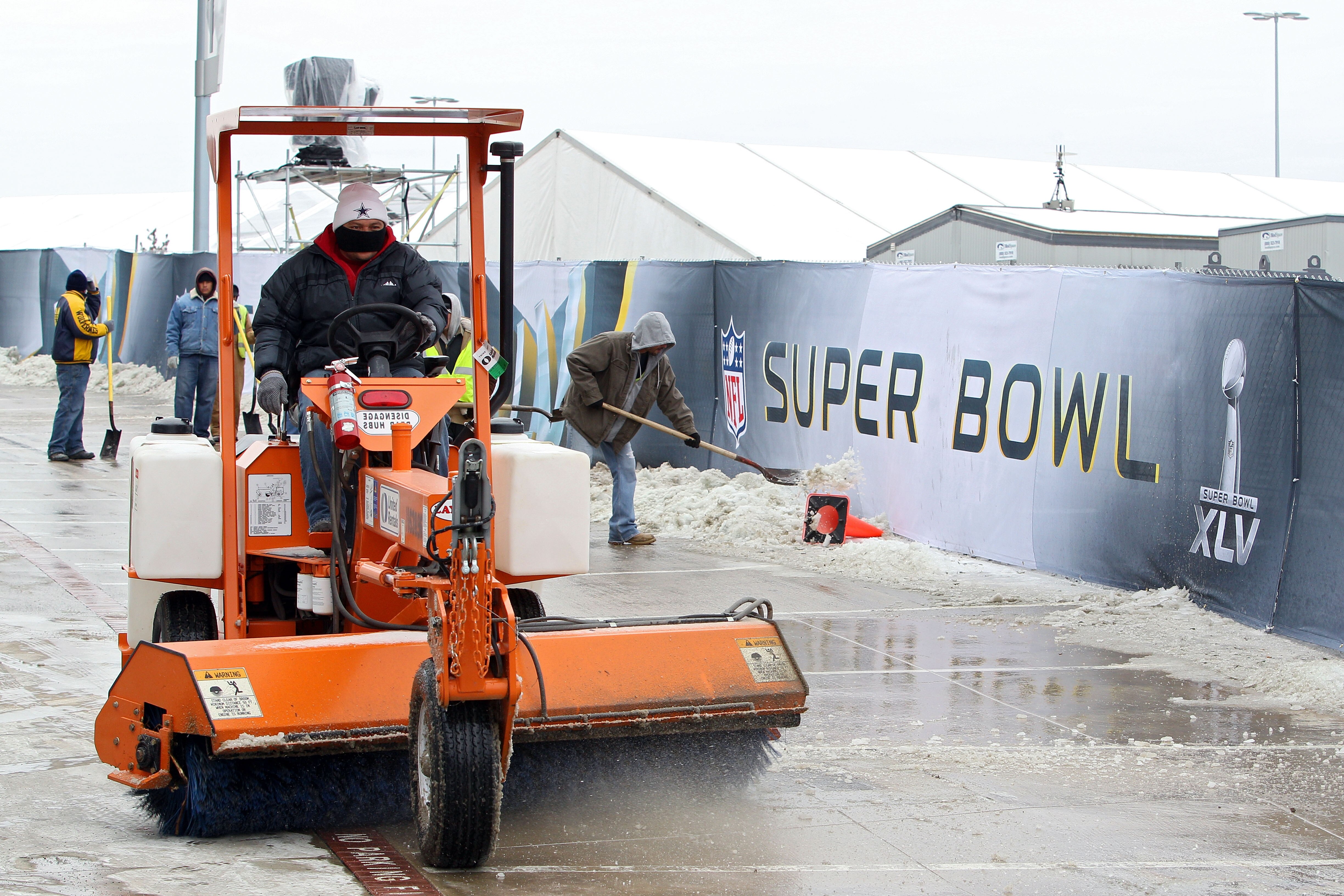 ARLINGTON, TX - FEBRUARY 04:  Workers use shovels and machinery to clear ice and snow on February 3, 2011 outside of Cowboy Stadium in Arlington, Texas. Cowboys Stadium will host Super Bowl XLV on February 6, 2011 between the Pittsburgh Steelers and the G