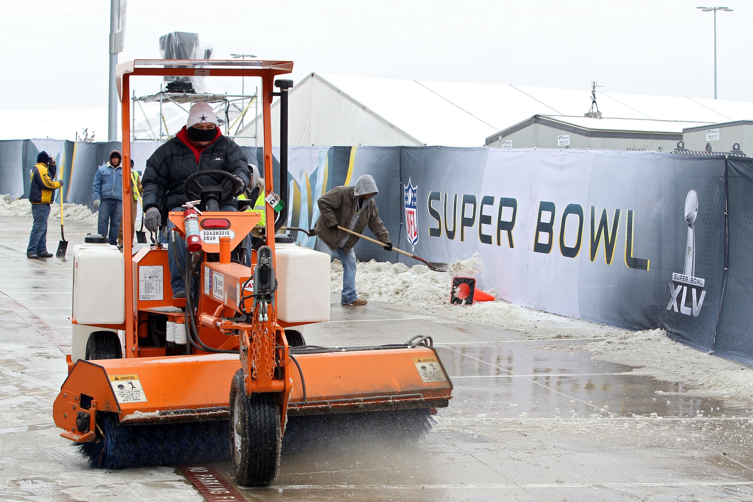 ARLINGTON, TX - FEBRUARY 04:  Workers use shovels and machinery to clear ice and snow on February 3, 2011 outside of Cowboy Stadium in Arlington, Texas. Cowboys Stadium will host Super Bowl XLV on February 6, 2011 between the Pittsburgh Steelers and the G