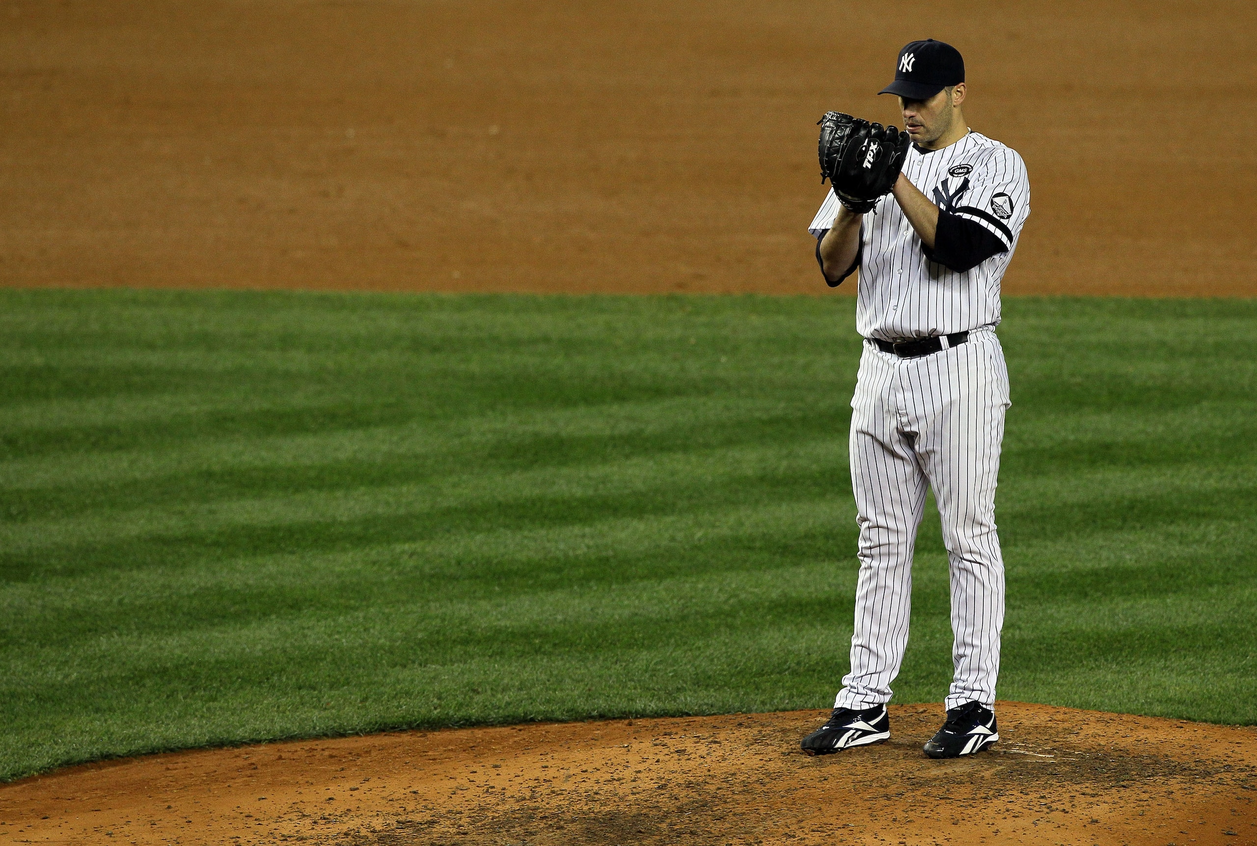 NEW YORK - OCTOBER 18:  Starting pitcher Andy Pettitte #46 of the New York Yankees gets set to throw a pitch against the Texas Rangers in Game Three of the ALCS during the 2010 MLB Playoffs at Yankee Stadium on October 18, 2010 in New York, New York.  (Ph