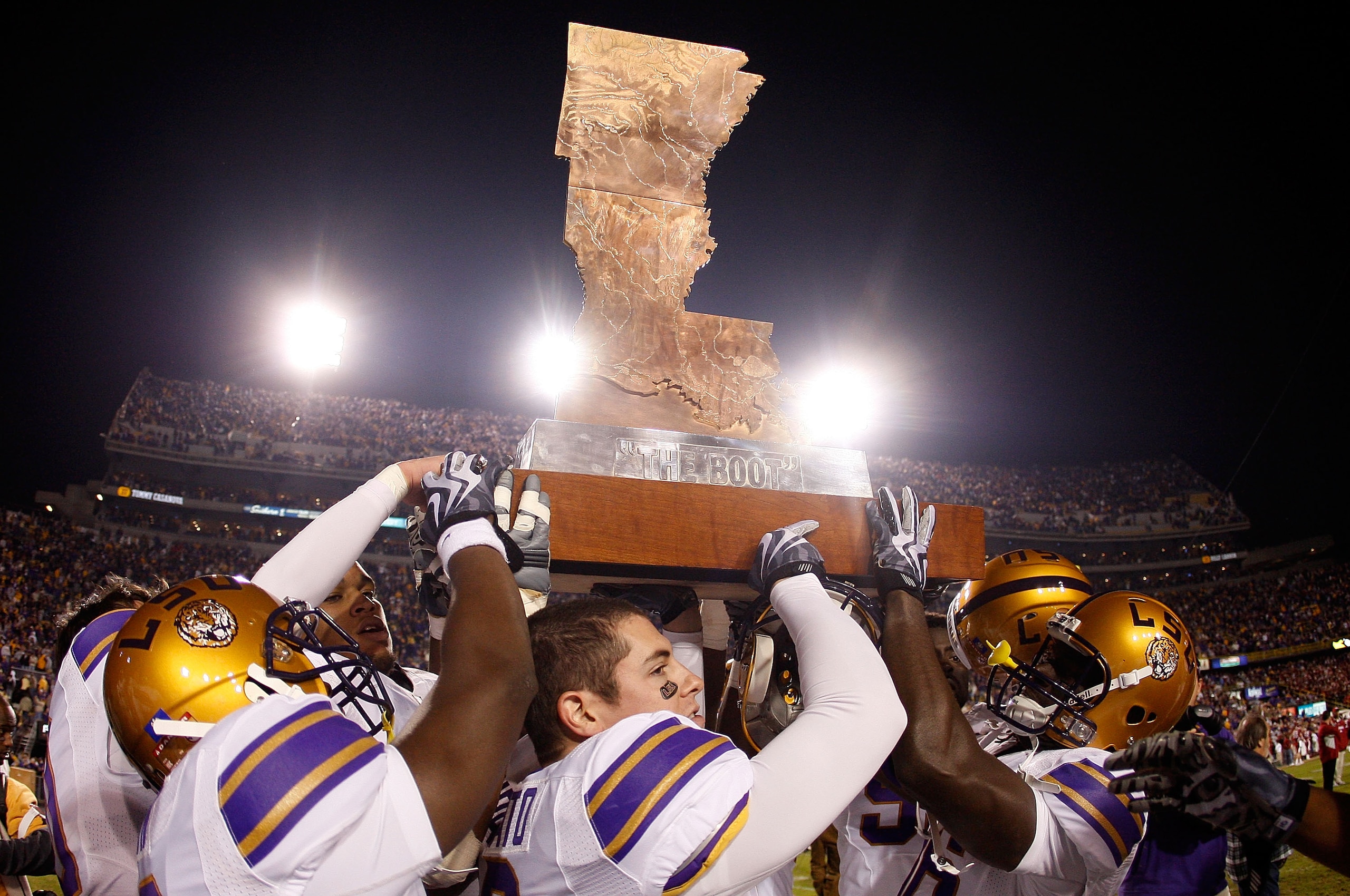 BATON ROUGE, LA - NOVEMBER 28:  Members of the LSU Tigers celebrate with 'The Boot' trophy after defeating the Arkansas Razorbacks 33-30 in overtime at Tiger Stadium on November 28, 2009 in Baton Rouge, Louisiana.  (Photo by Chris Graythen/Getty Images)