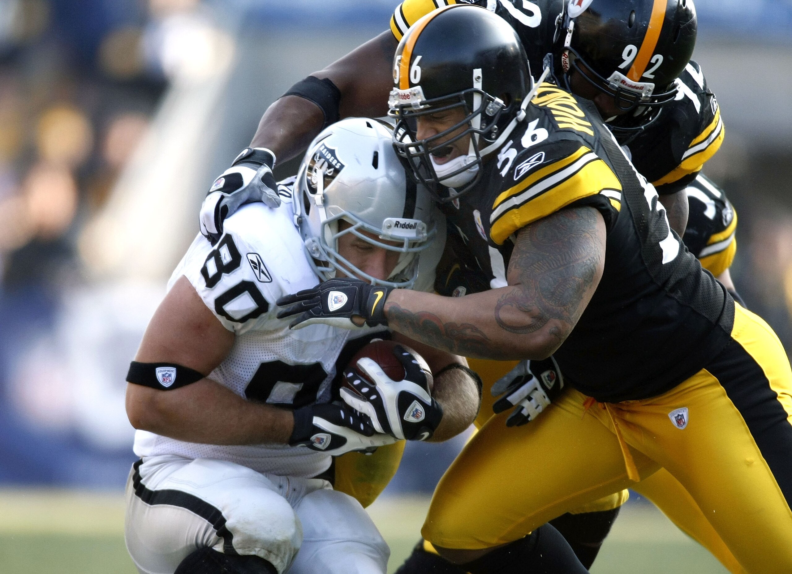 PITTSBURGH - DECEMBER 06:  Zach Miller #80 of the Oakland Raiders is tackled after a second quarter catch by LaMarr Woodley #56 of the Pittsburgh Steelers on December 6, 2009 at Heinz Field in Pittsburgh, Pennsylvania.  (Photo by Gregory Shamus/Getty Imag