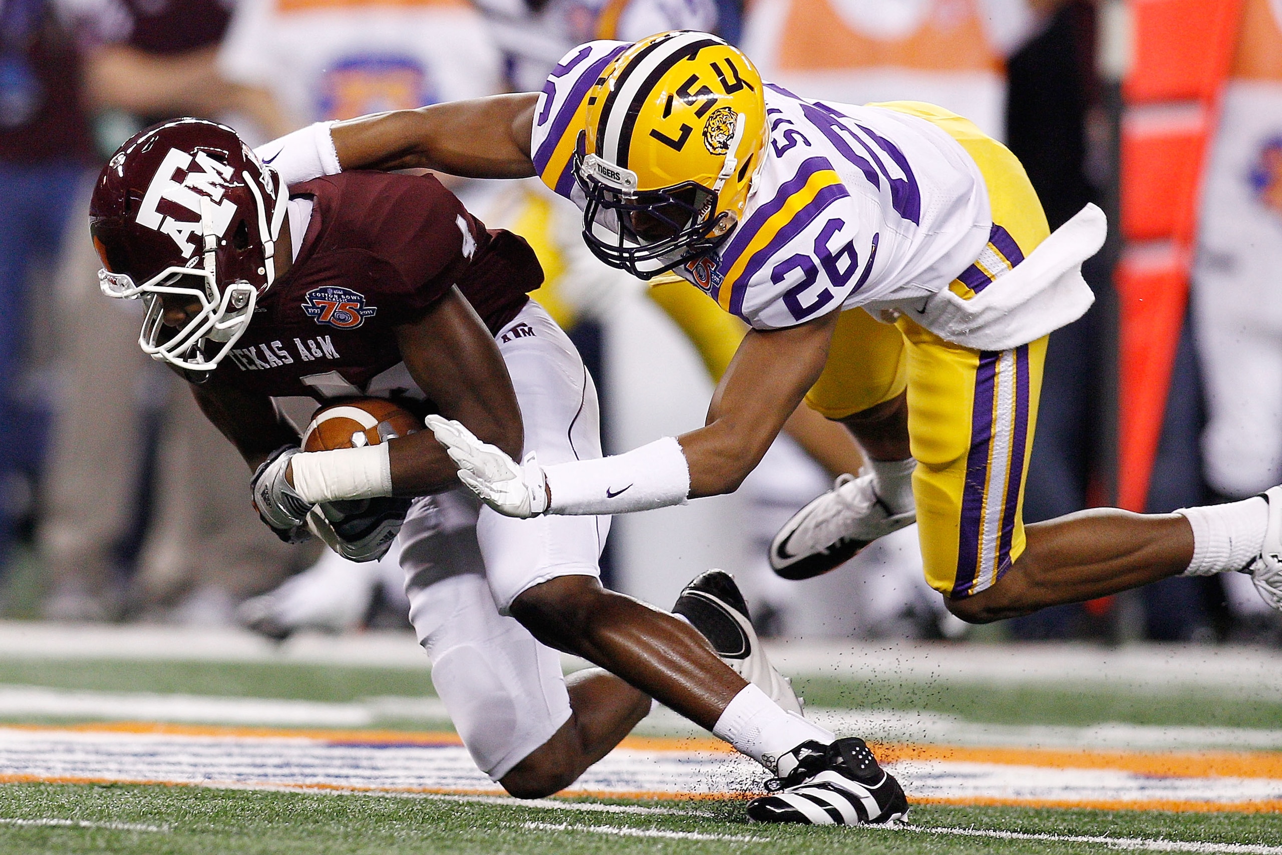 ARLINGTON, TX - JANUARY 07:  Brandal Jackson #4 of the Texas A&M Aggies is tackled by Tharold Simon #26 of the Louisiana State University Tigers during the AT&T Cotton Bowl at Cowboys Stadium on January 7, 2011 in Arlington, Texas.  (Photo by Chris Grayth