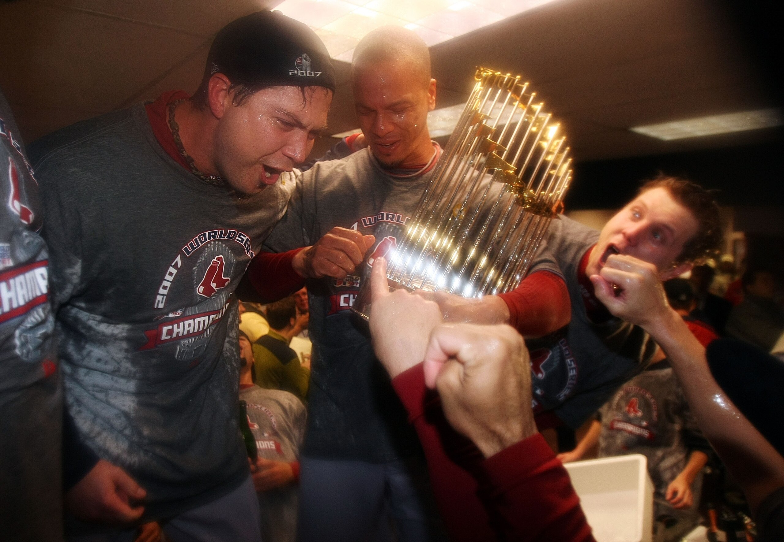 DENVER - OCTOBER 28:  (L-R) Josh Beckett #19, Julio Lugo #23 and Jonathan Papelbon #18 of the Boston Red Sox celebrate with the trophy in the locker room after winning Game Four by a score of 4-3 to win the 2007 Major League Baseball World Series in a fou