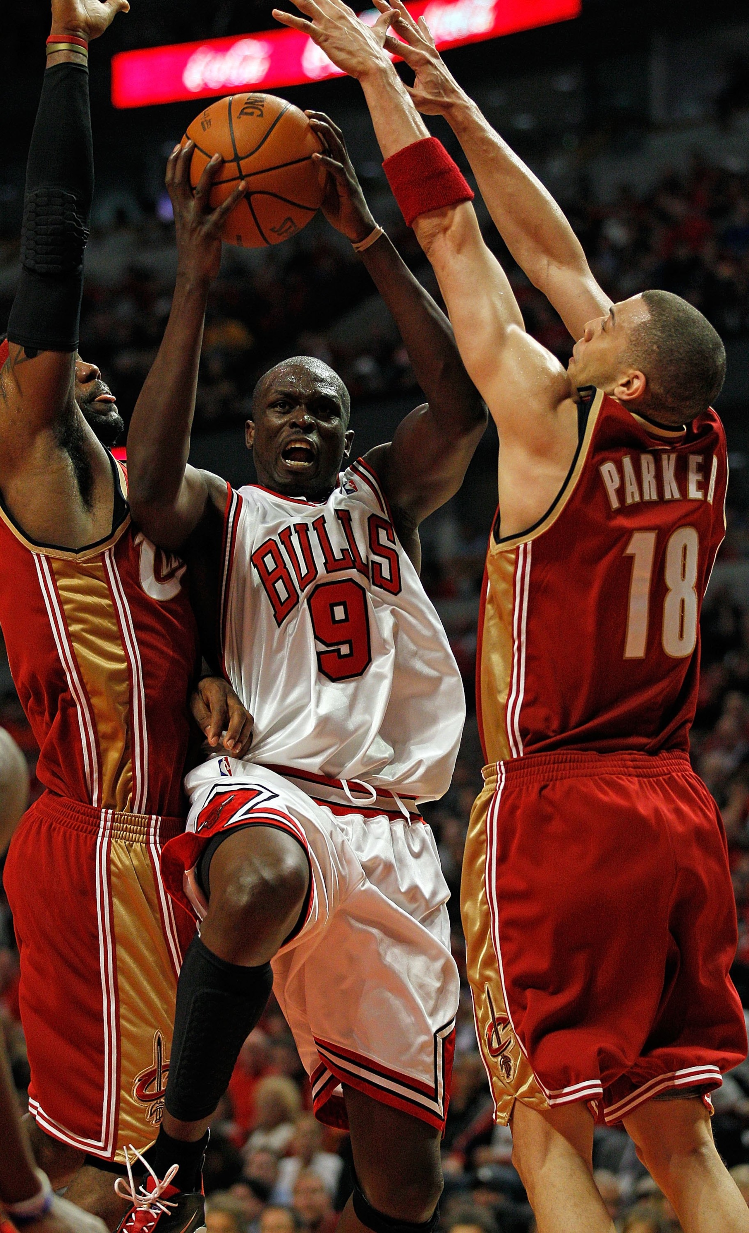 CHICAGO - APRIL 25: Luol Deng #9 of the Chicago Bulls goes up for shot between LeBron James #23 (L) and Anthony Parker #18 of the Cleveland Cavaliers in Game Four of the Eastern Conference Quarterfinals during the 2010 NBA Playoffs at the United Center on
