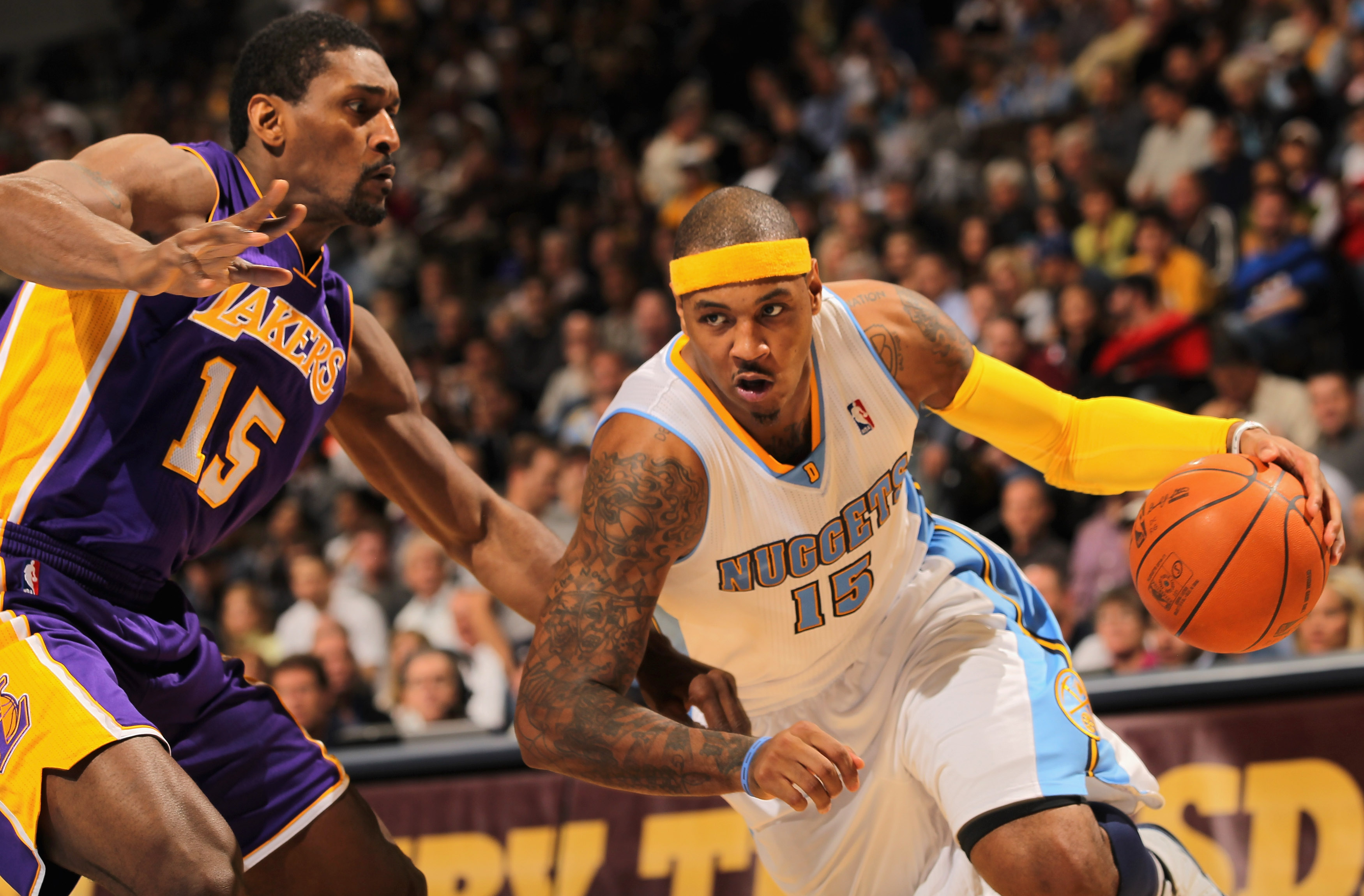 DENVER - NOVEMBER 11:  Carmelo Anthony #15 of the Denver Nuggets drives past Ron Artest #15 of the Los Angeles Lakers at Pepsi Center on November 11, 2010 in Denver, Colorado. The Nuggets defeated the Lakers 118-112.  NOTE TO USER: User expressly acknowle
