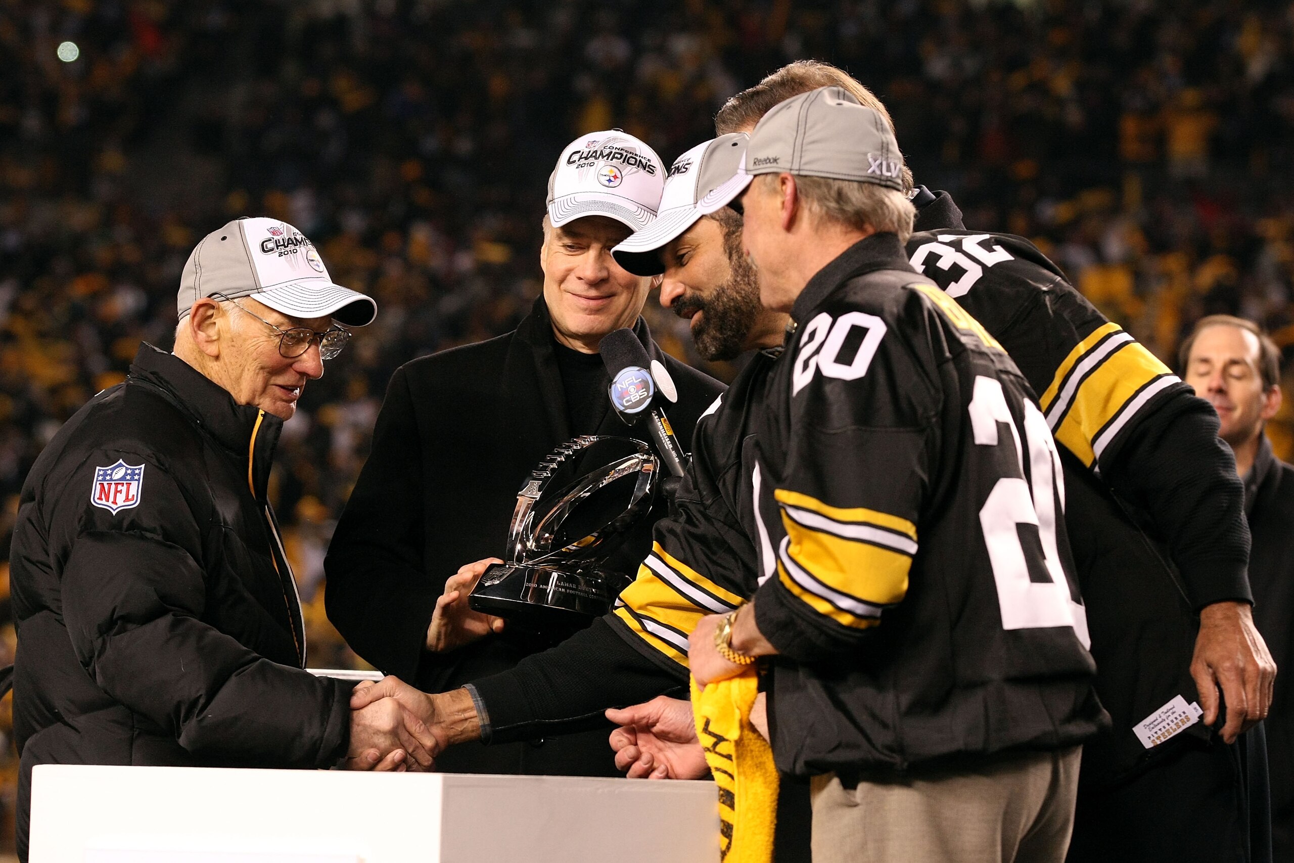 PITTSBURGH, PA - JANUARY 23:  Owner Dan Rooney (L) and Team president Art Rooney II (2ndL) of the Pittsburgh Steelers recieve the Lamar Hunt Trophy from former Steelers' players Franco Harris and Rocky Bleier (R) after their 24 to 19 win over the New York