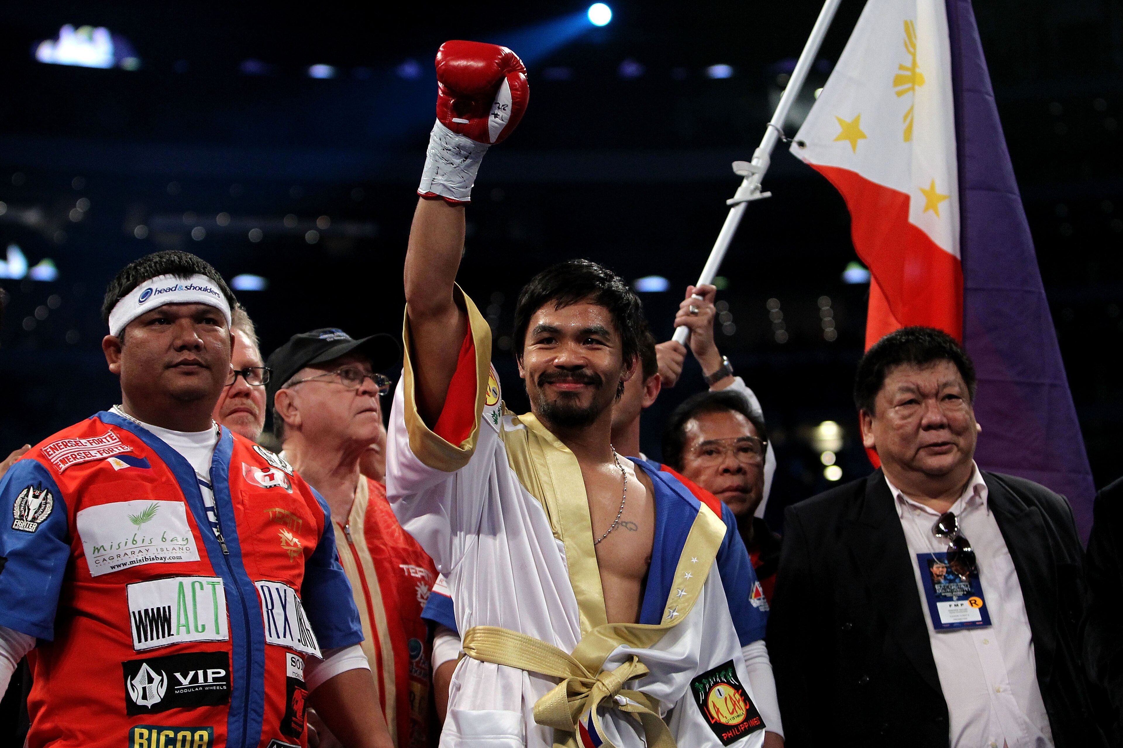 ARLINGTON, TX - NOVEMBER 13:  Manny Pacquiao (white trunks) of the Philippines raises his hand in the air as he stands in the ring waiting to fight against Antonio Margarito (black trunks) of Mexico during their WBC World Super Welterweight Title bout at 