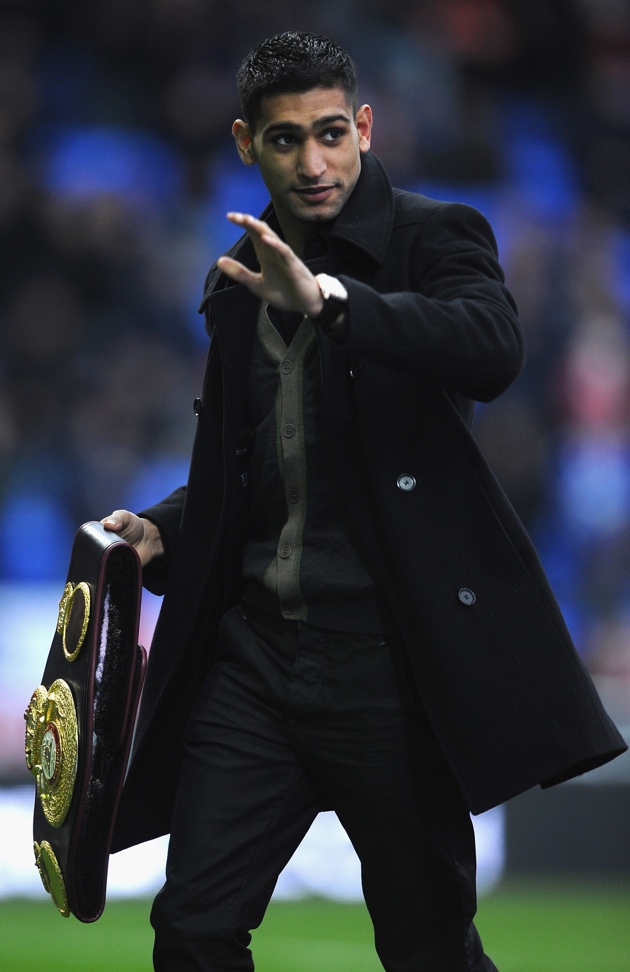 BOLTON, ENGLAND - DECEMBER 26:  Boxer Amir Khan shows his latest belt to the crowd during the Barclays Premier League match between Bolton Wanderers and West Bromwich Albion at Reebok Stadium on December 26, 2010 in Bolton, England.  (Photo by Laurence Gr