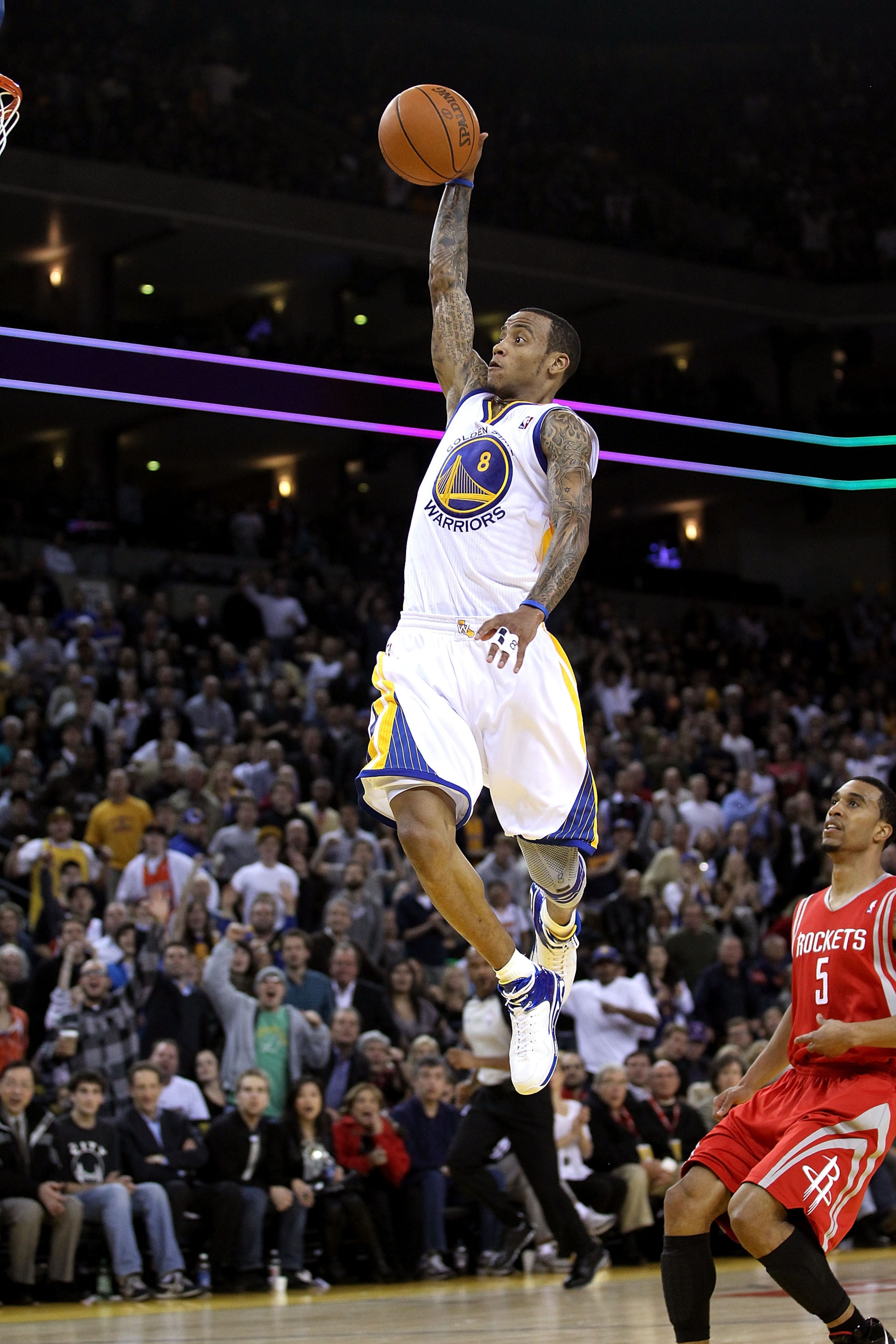 OAKLAND, CA - DECEMBER 20:  Monta Ellis #8 of the Golden State Warriors dunks the ball over Courtney Lee #5 of the Houston Rockets at Oracle Arena on December 20, 2010 in Oakland, California. NOTE TO USER: User expressly acknowledges and agrees that, by d